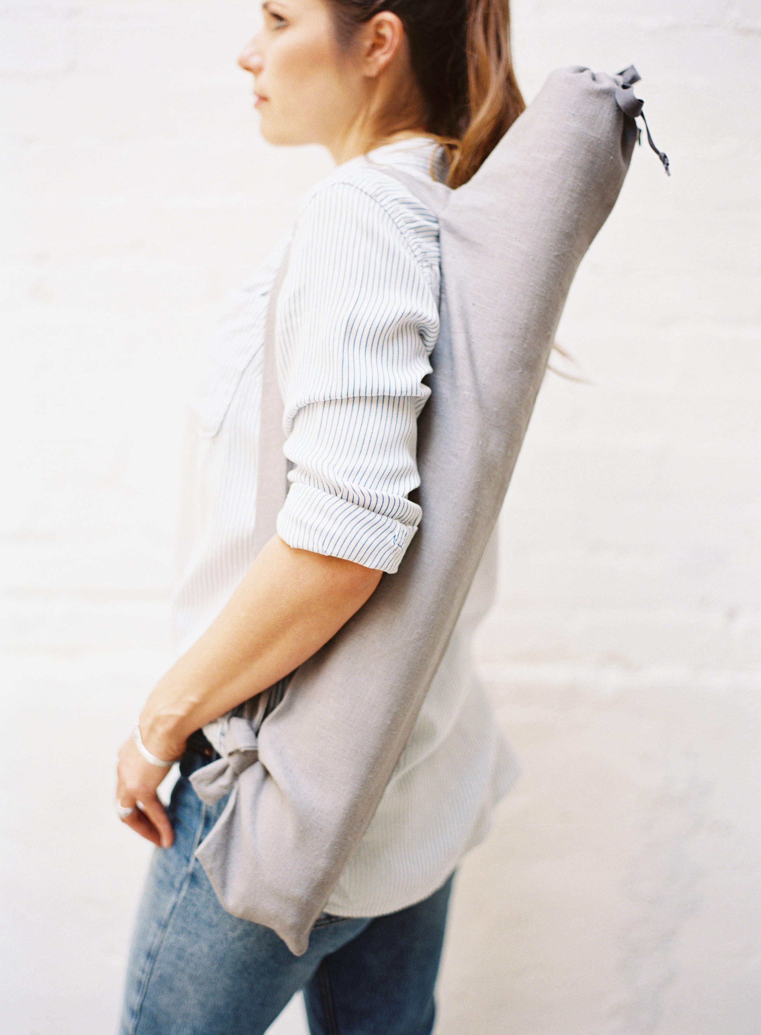 photographer carrying rolled photography backdrop in protective storage case for portable studio setup