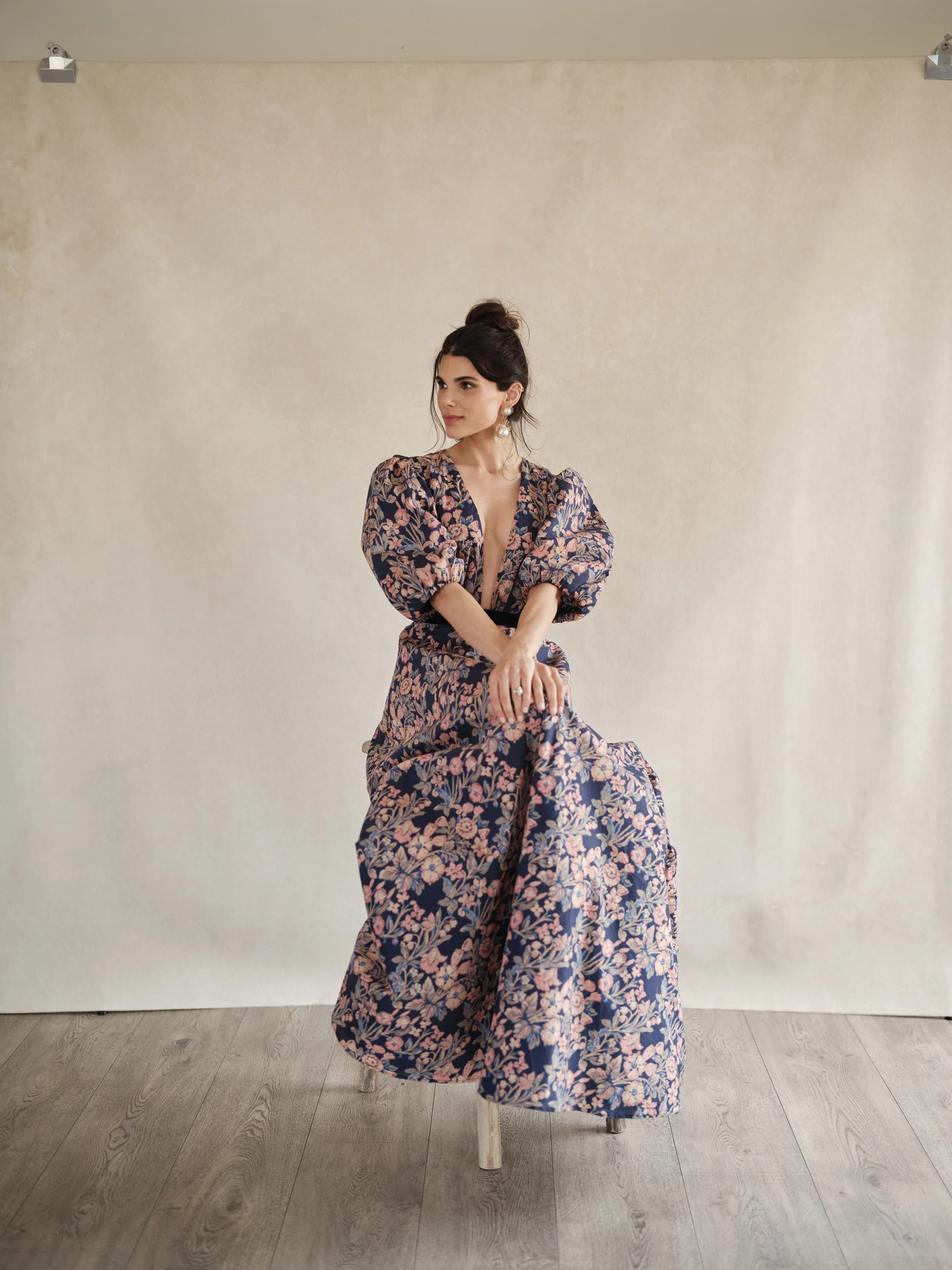 editorial fashion portrait on Sandstone hand-painted canvas backdrop showing natural subject separation and textured neutral peach surface