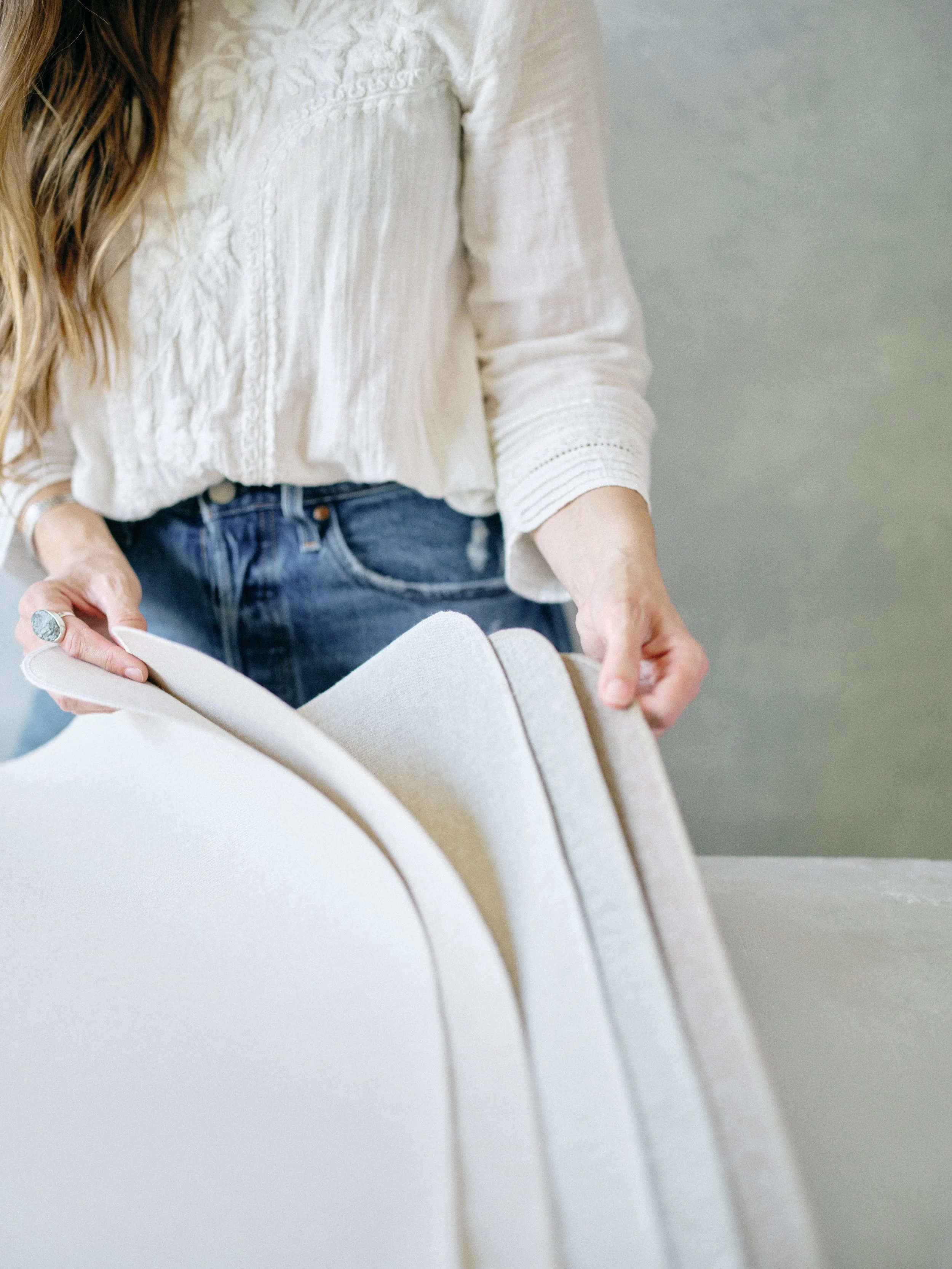 Wedding photographer inspecting a rolled hand-painted canvas backdrop before spring season