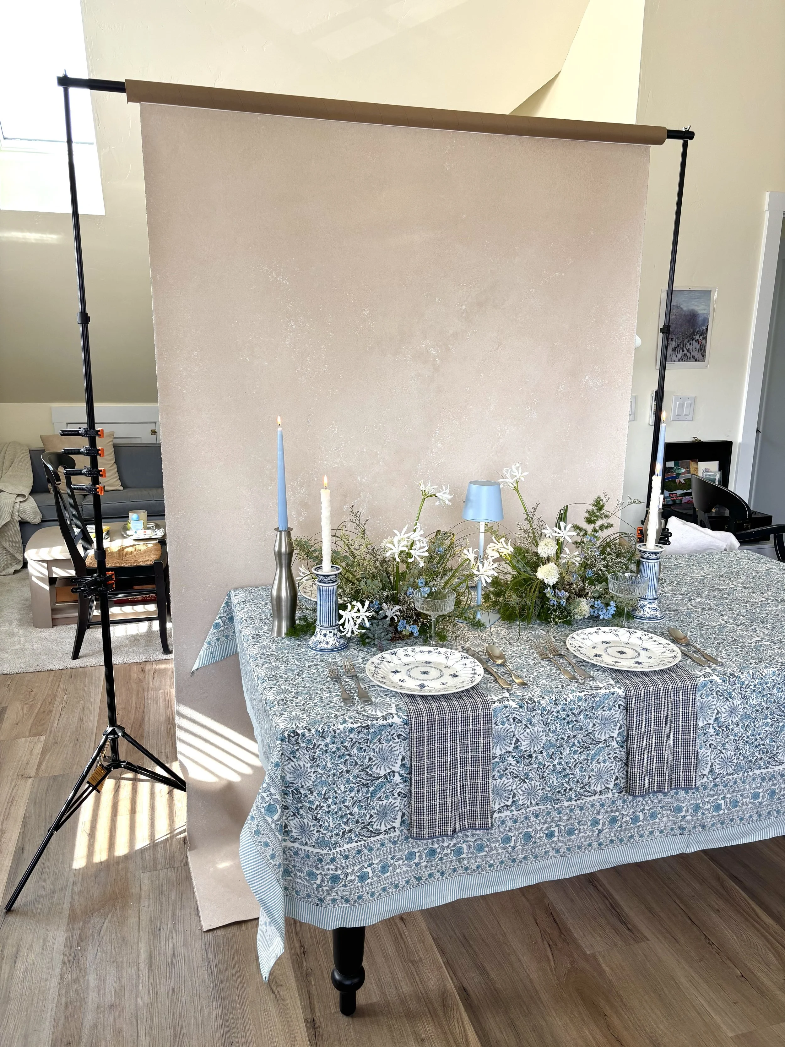blush hand-painted canvas backdrop on stand with styled blue and white tablescape in front