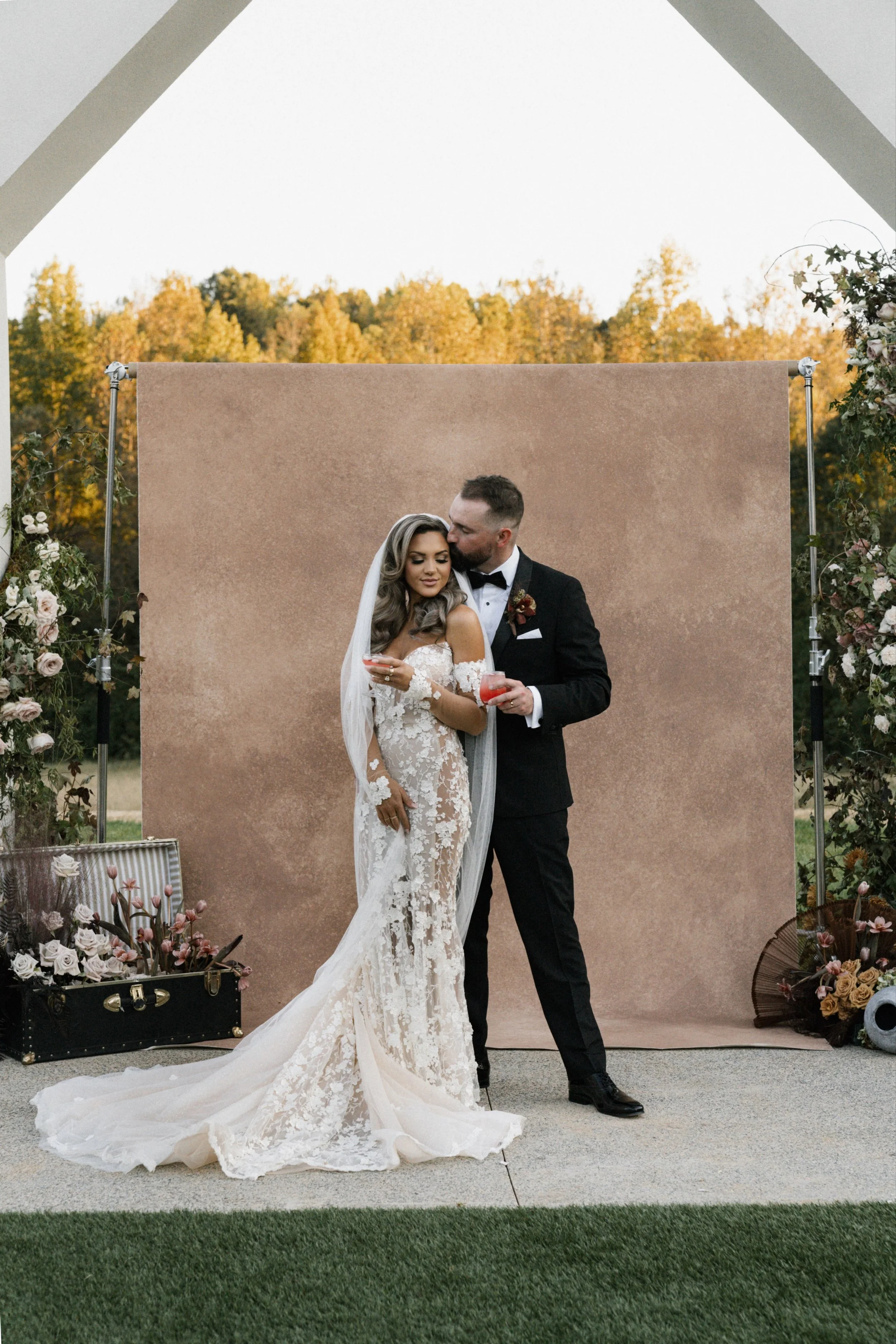Bride and groom portrait at golden hour photographed outdoors with a hand painted canvas backdrop
