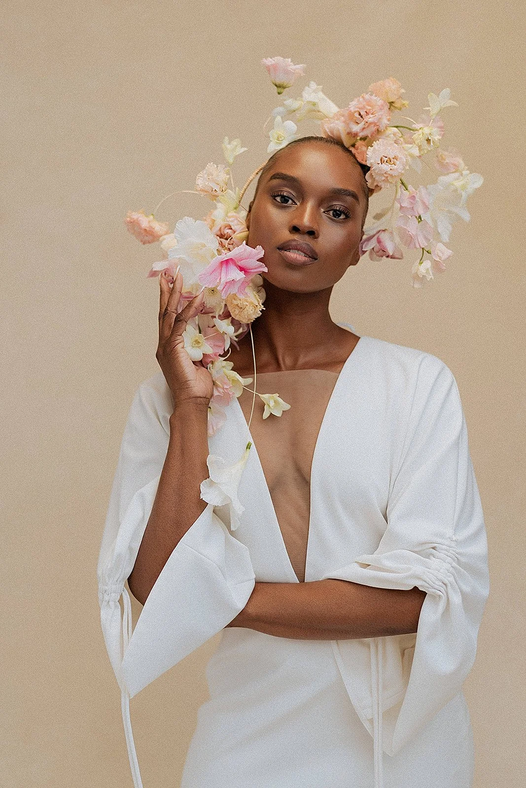 Portrait of a woman with a floral crown against a warm taupe hand-painted canvas backdrop, demonstrating how Chasing Stone neutral backdrops flatter all skin tones for professional portrait and headshot photography