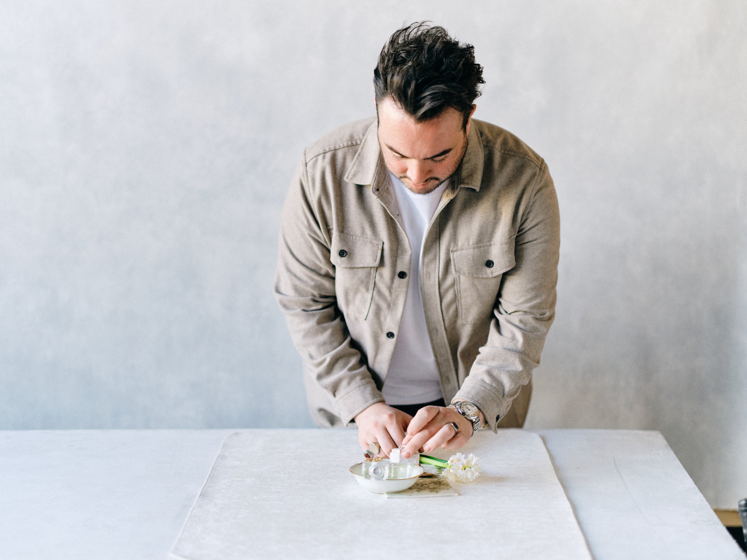 Professional photographer demonstrating intentional flat lay styling technique and proper overhead positioning