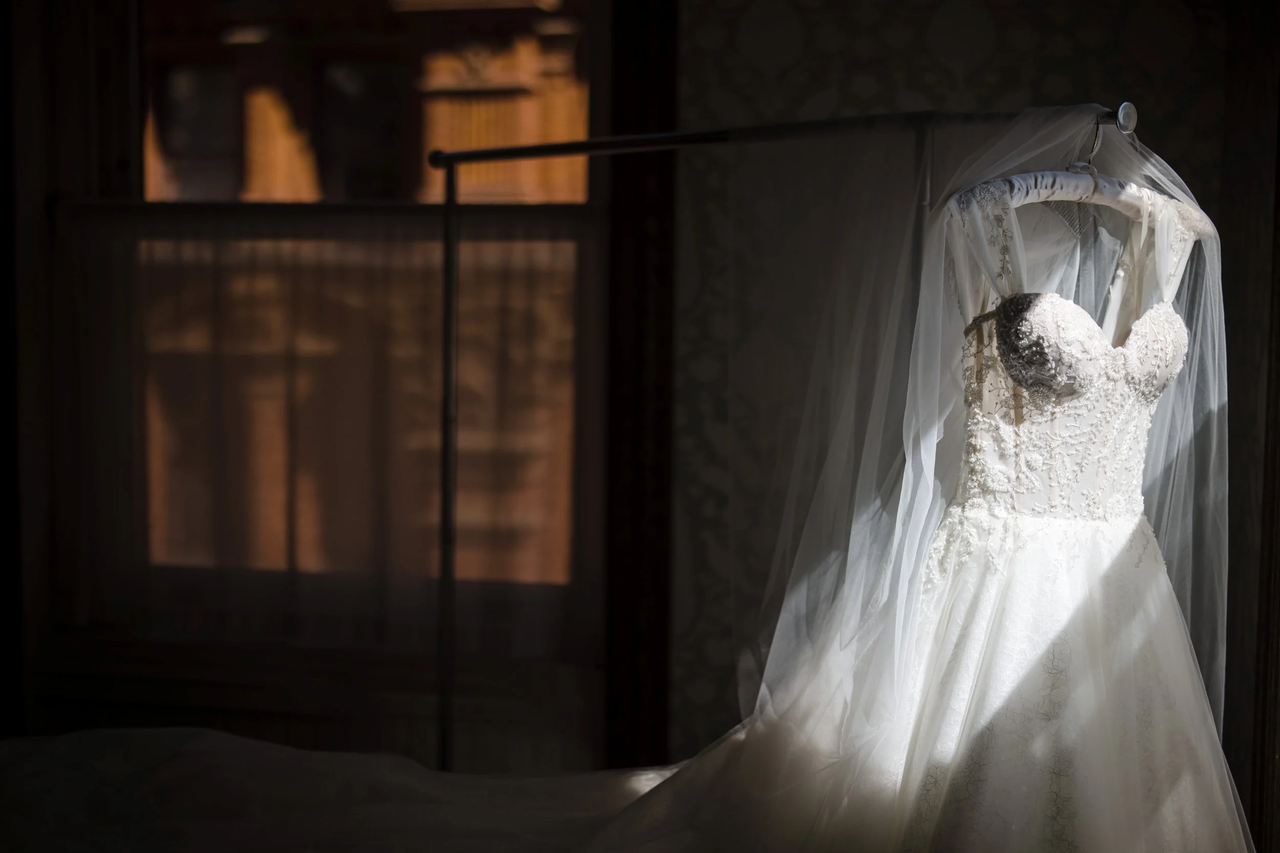 Wedding dress lace ballgown veil dramatic window light hotel room getting ready photography detail shot