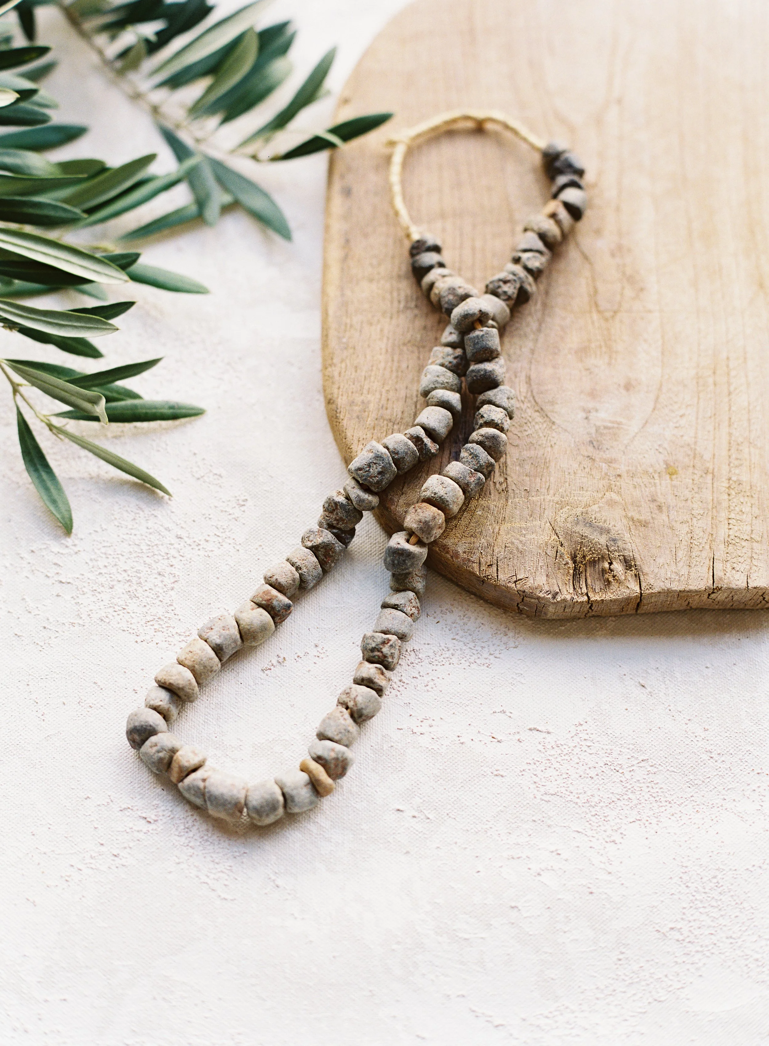 hand-painted warm neutral canvas backdrop for product photography with natural stone jewelry and organic flat lay styling