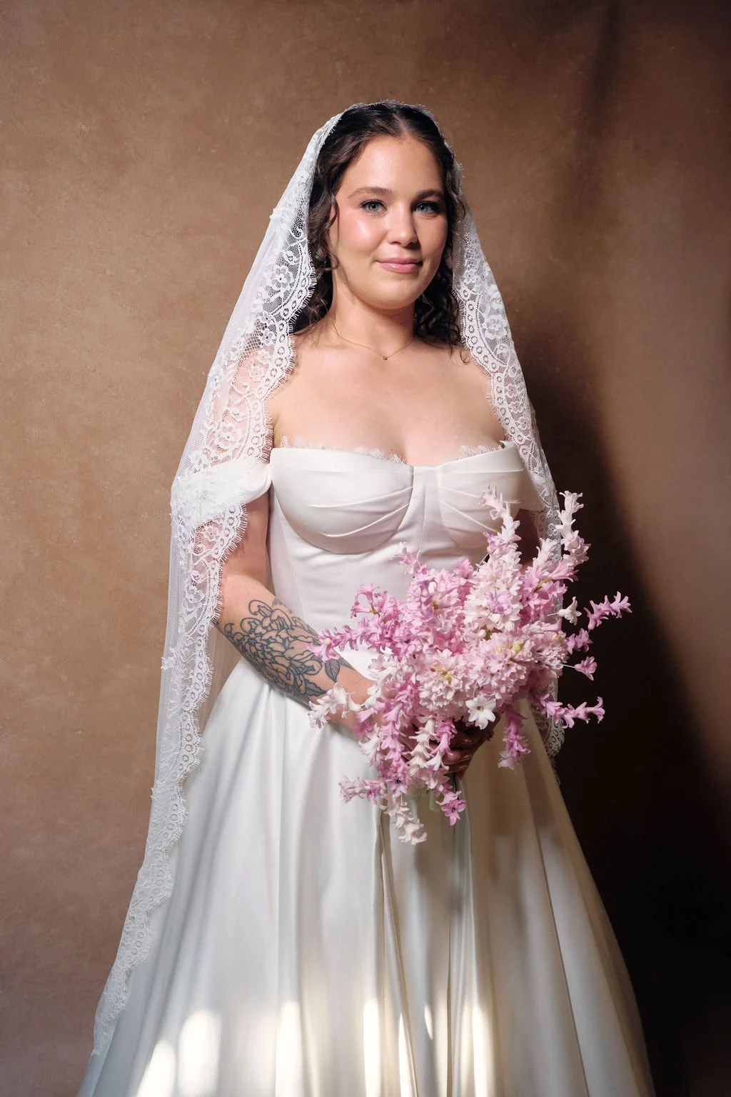 fine art bridal portrait on a CLAY hand-painted canvas backdrop with lace cathedral veil and pink bouquet