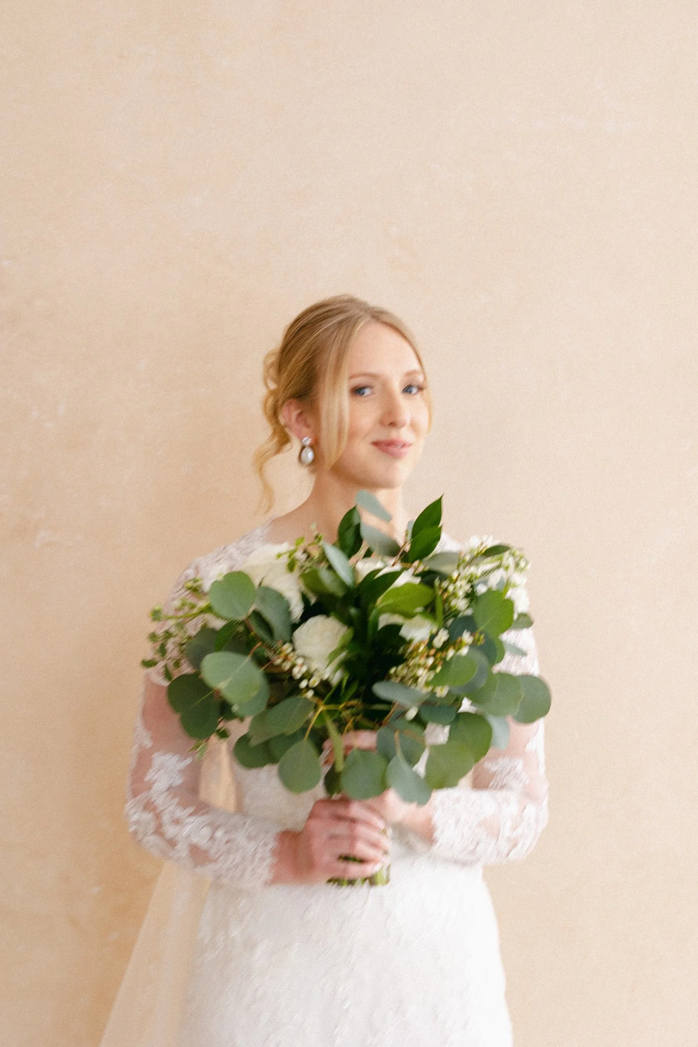 bride holding bouquet in front of a soft neutral 8x14 hand-painted canvas backdrop