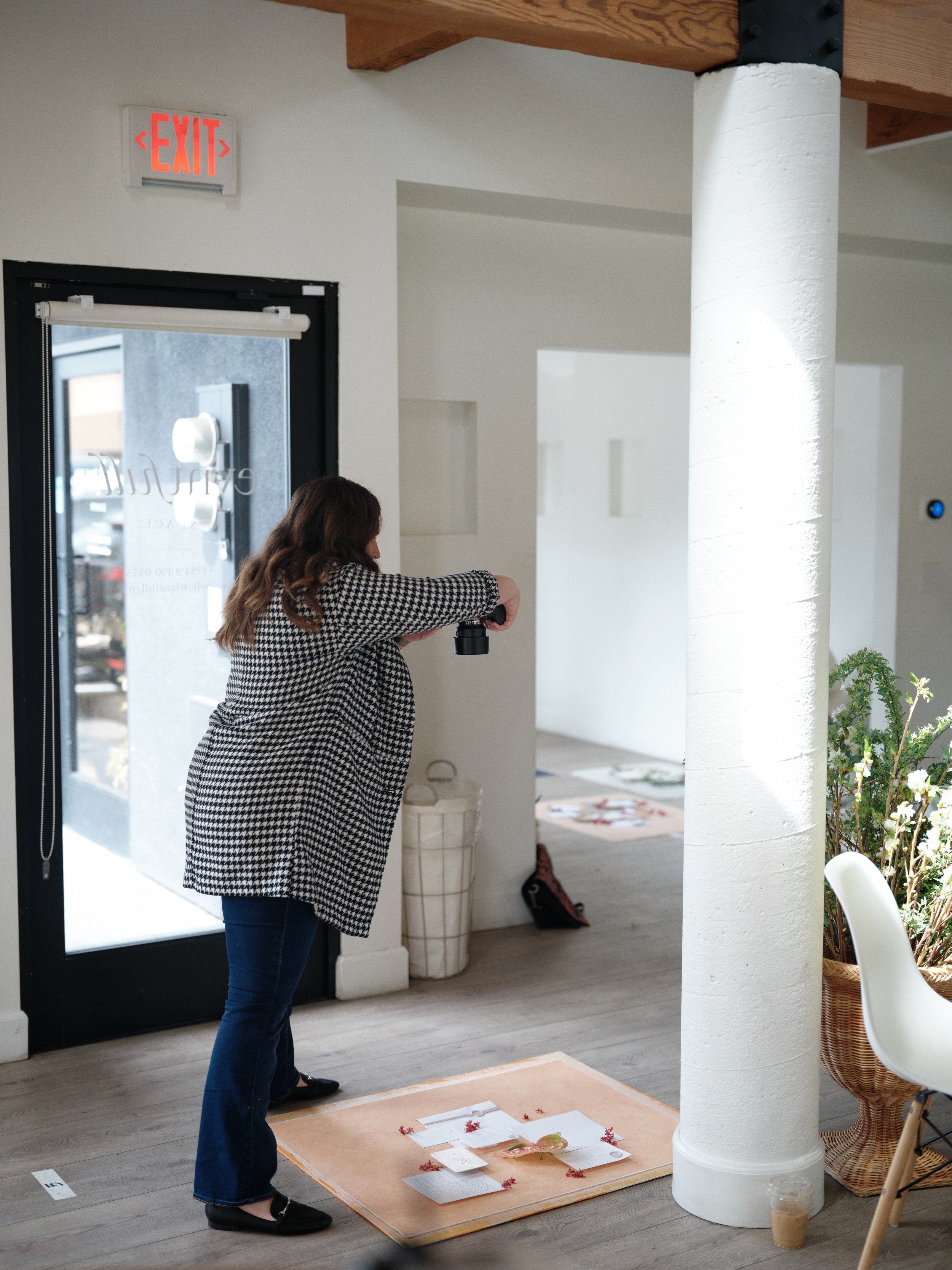 Behind-the-scenes look at a photographer shooting a flat lay overhead on a Chasing Stone hand-painted surface using natural window light
