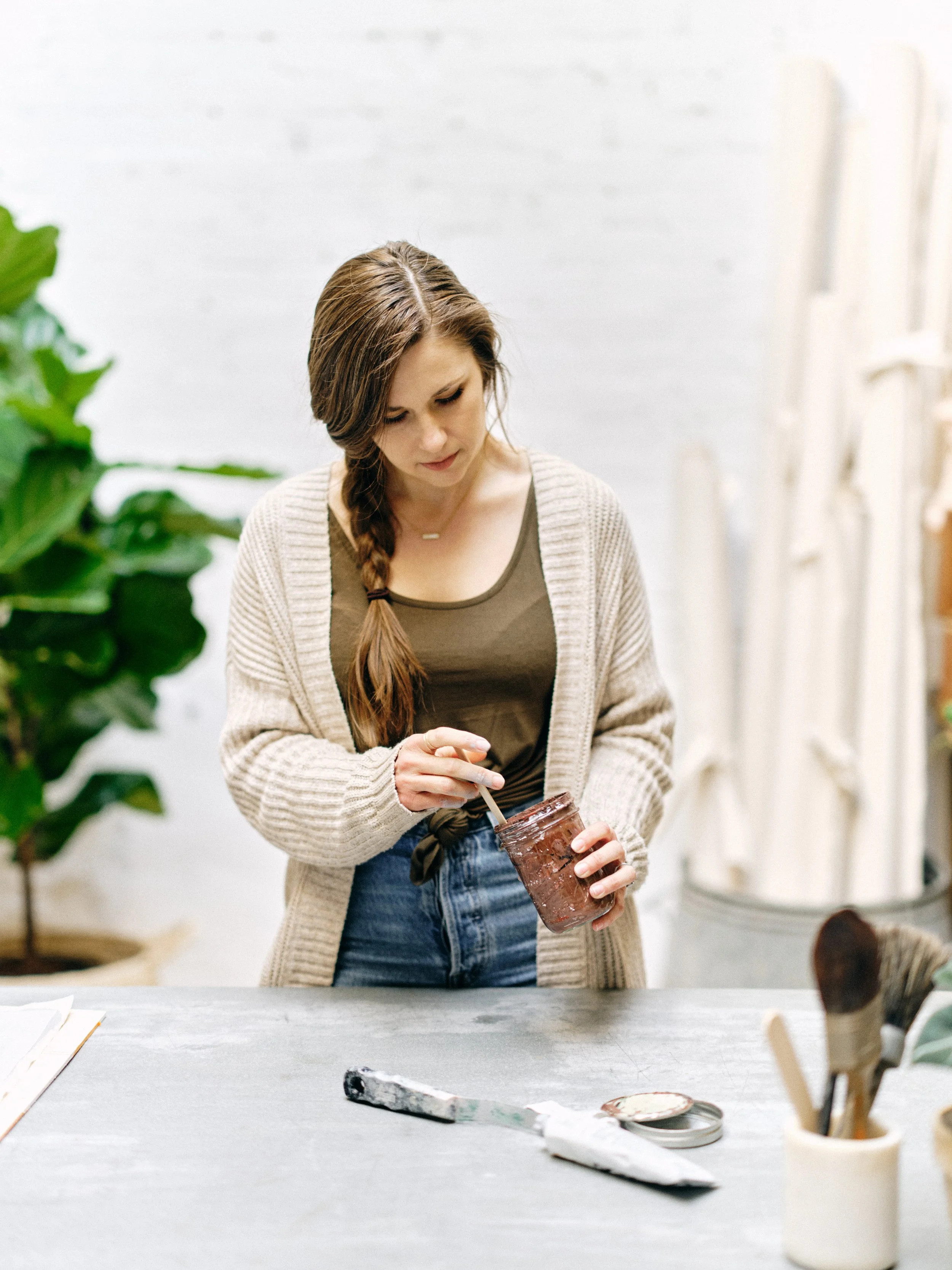 Chasing Stone artist Jennifer hand-mixing pigment in her studio, where each canvas backdrop is painted over two to three days