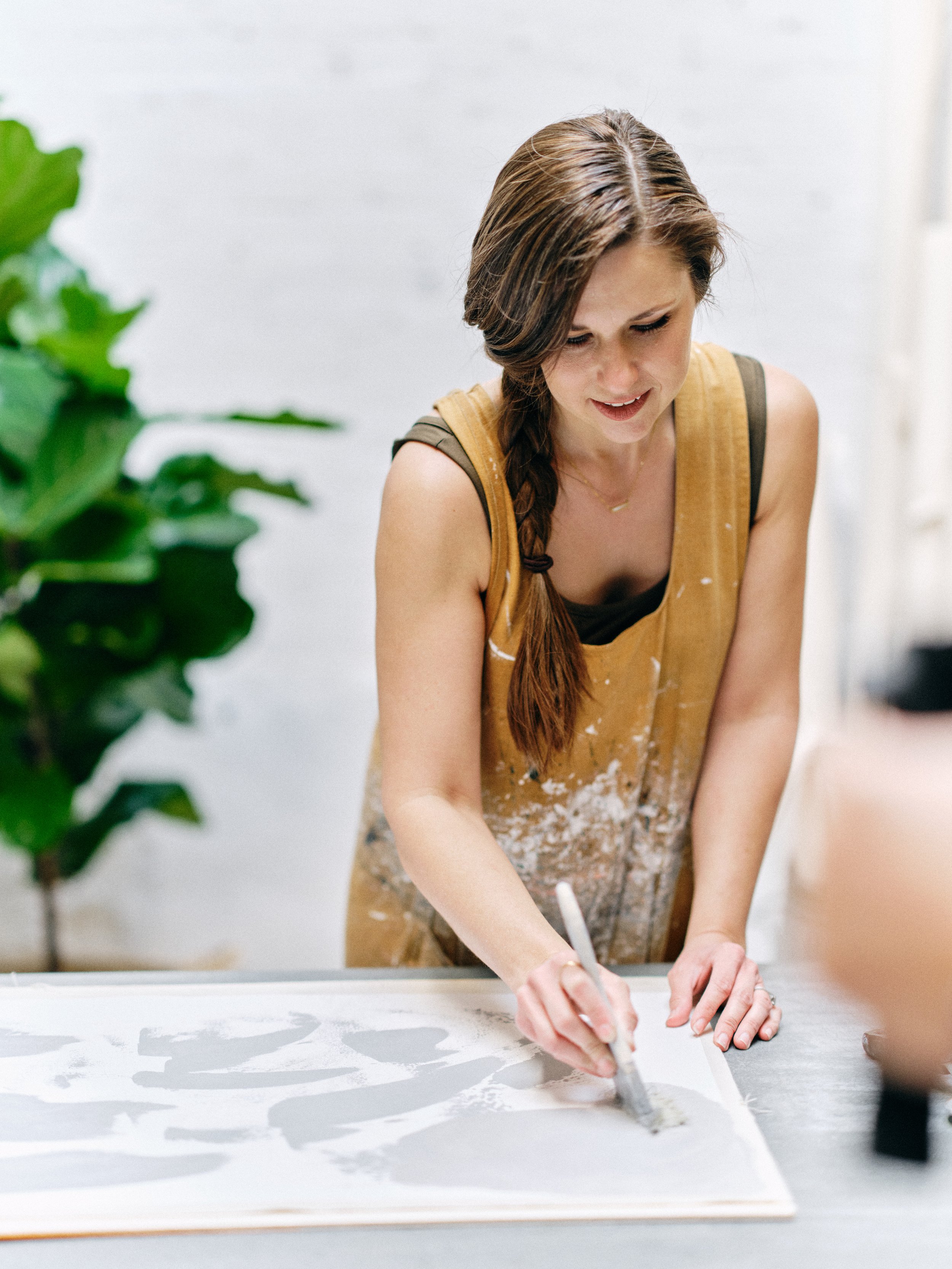 artist hand-painting texture onto canvas photography backdrop in Orange County studio using traditional brushwork techniques