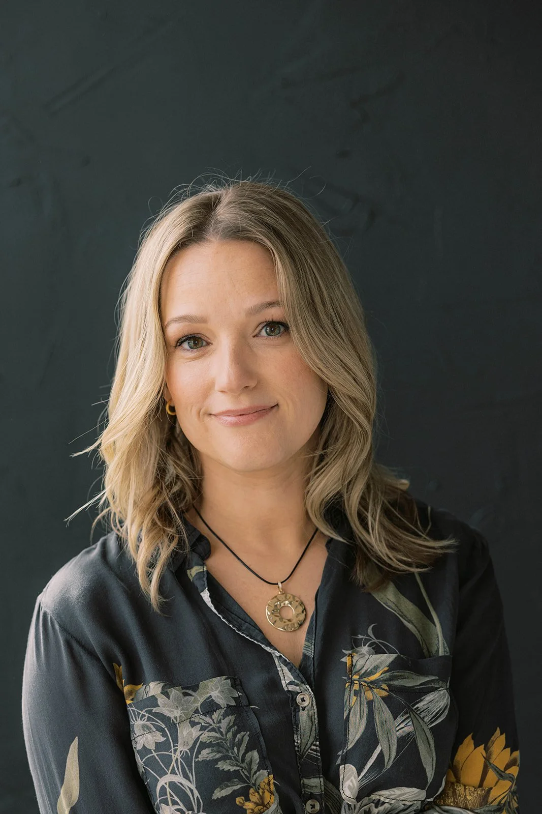 professional headshot portrait of a woman photographed against a dark photography backdrop
