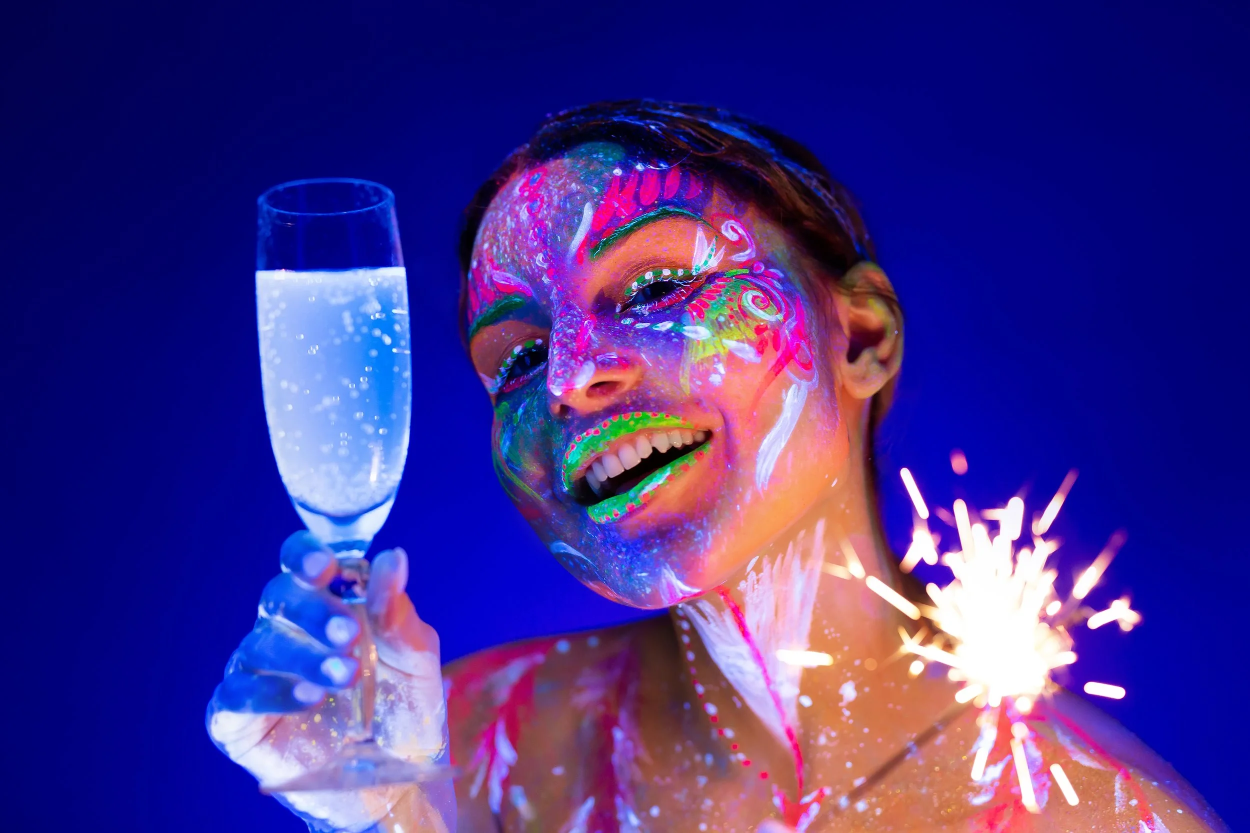woman-with-sparkler-and-glass-of-champagne-in-neon-2025-01-10-20-38-04-utc.jpg