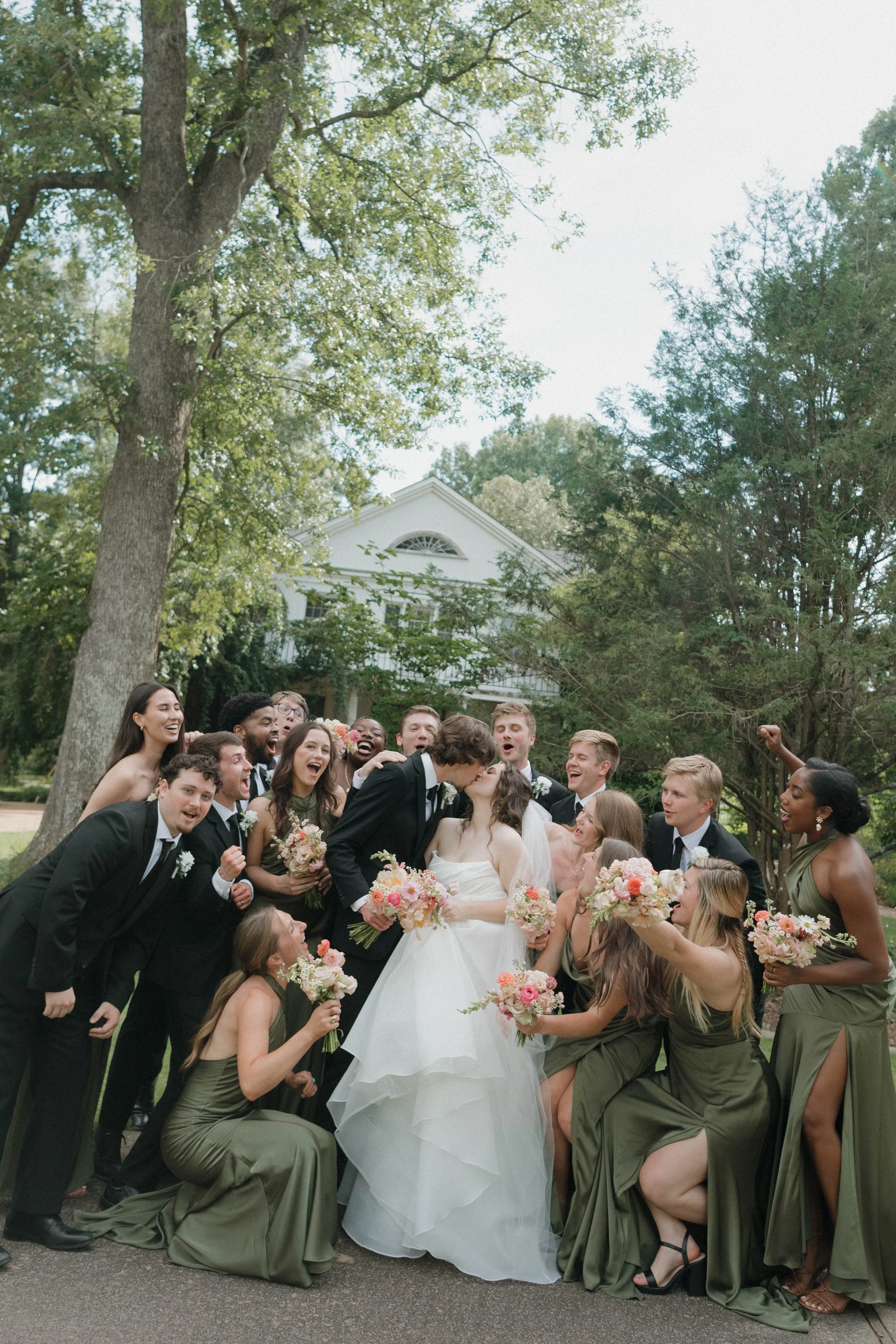 newly weds kissing with wedding party
