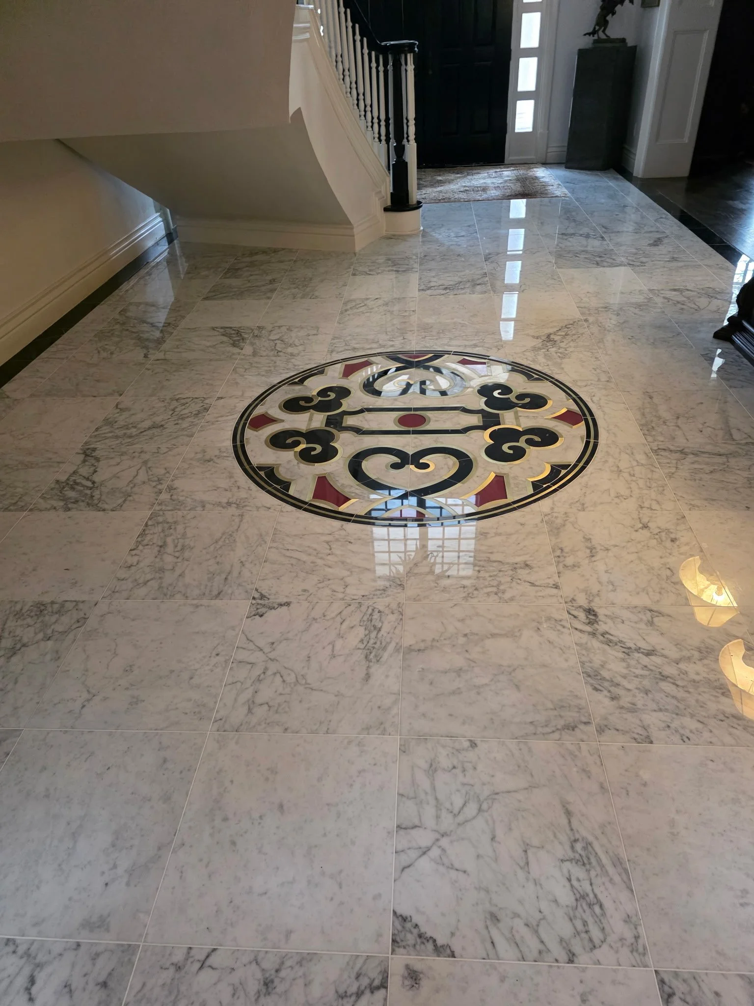 18x18 Carrera Polished Marble with custom Medallion Inlay and black border.