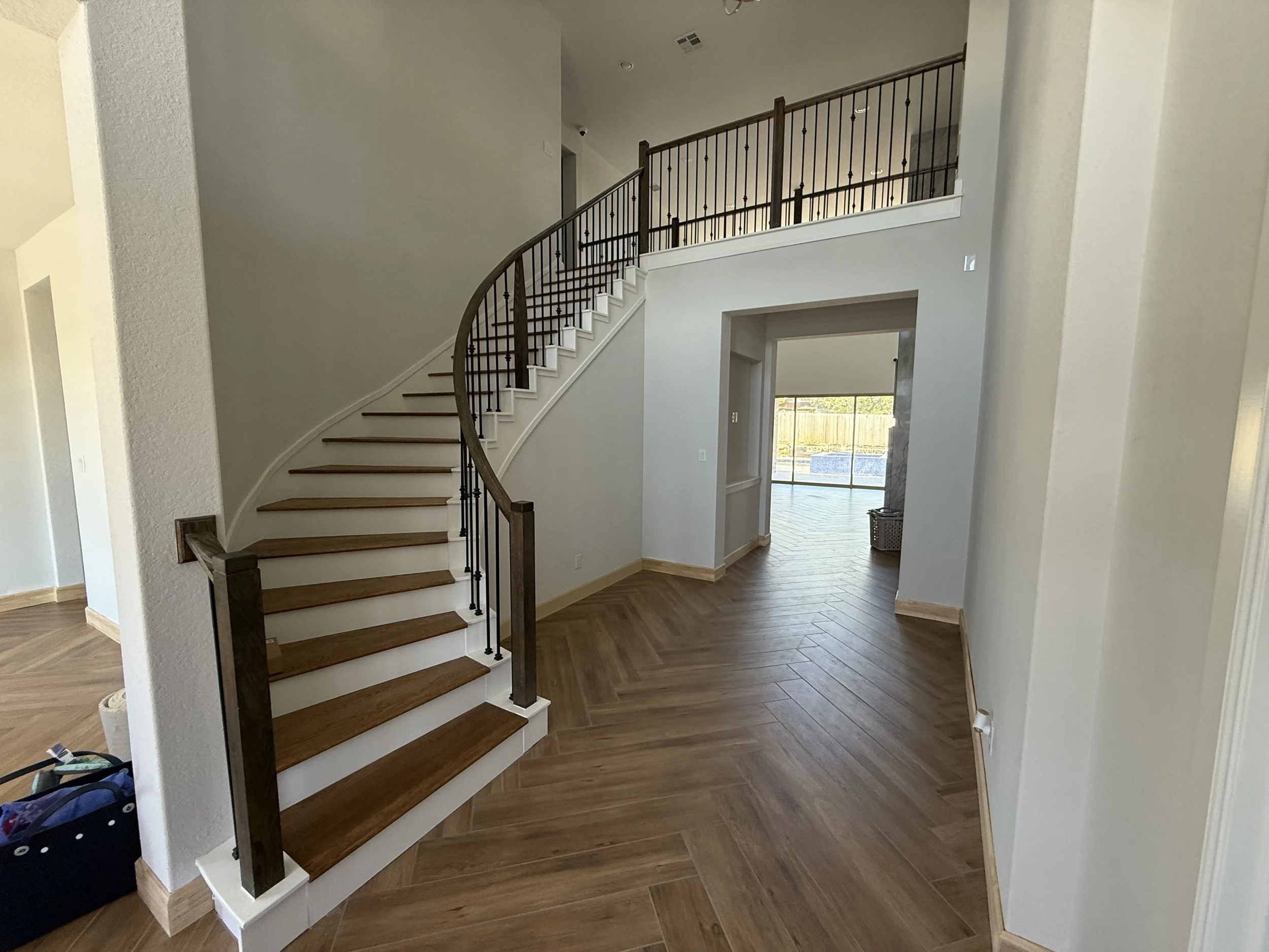 Porcelain tile planks laid in a Herringbone design with re-constructed staircase solid treads stained to match.
