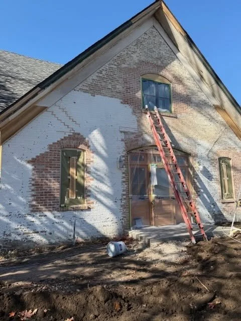 Beardsley Museum wall with exposed brick, masked openings, and a ladder.