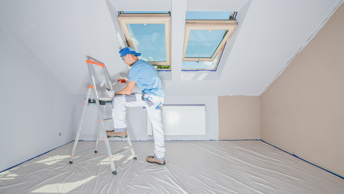 Interior house painter protecting floors and painting a room in Northern Indiana