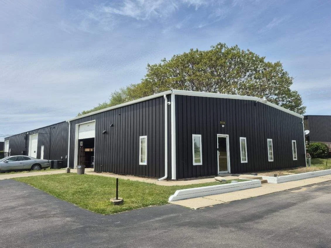 Pokeden building exterior with black siding and white trim.