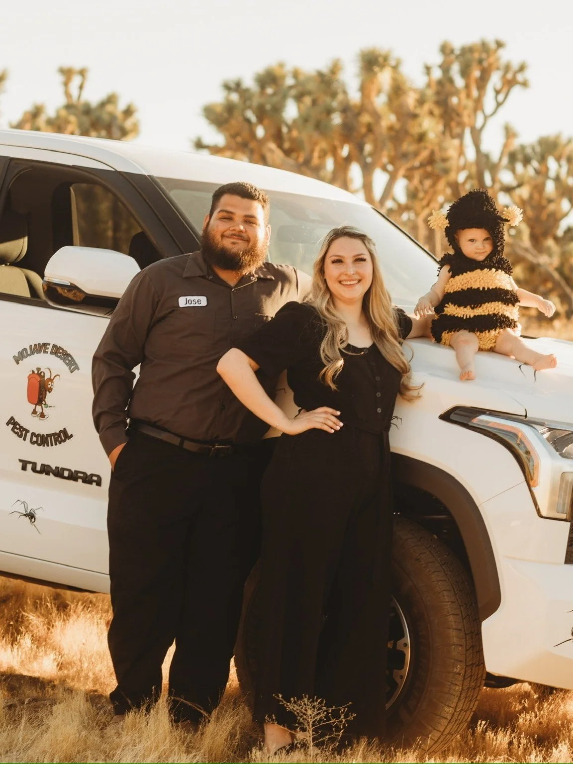 Jose and Sierra, owners of Mojave Desert Pest Control, standing in Yucca Valley, CA with their branded service truck.