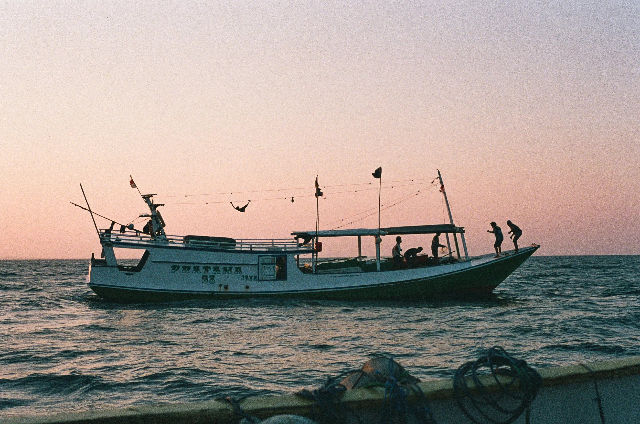 The crew aboard an Indonesian fishing boat at sunset