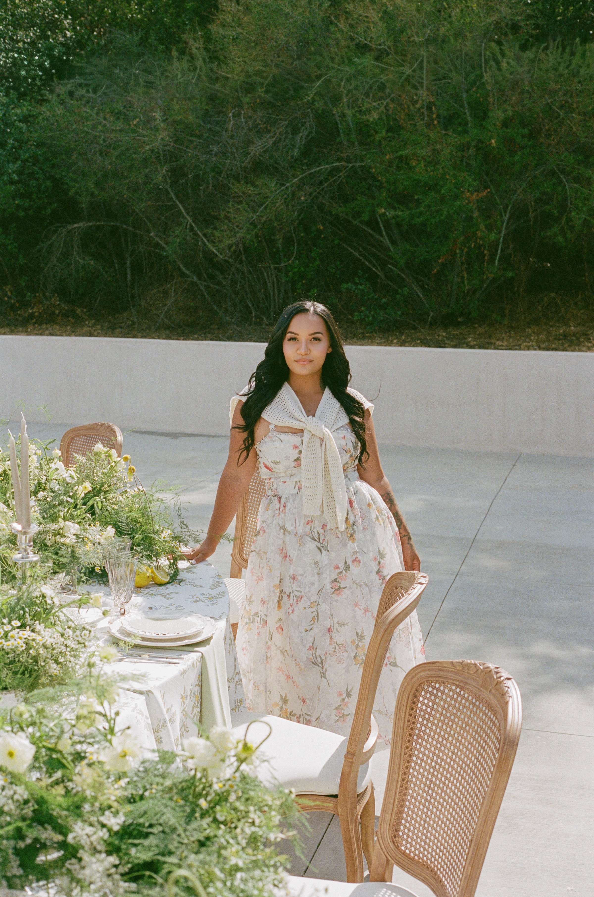 Carlina, founder of Teardrop Wedding Events, standing beside a garden-inspired wedding tablescape in Southern California