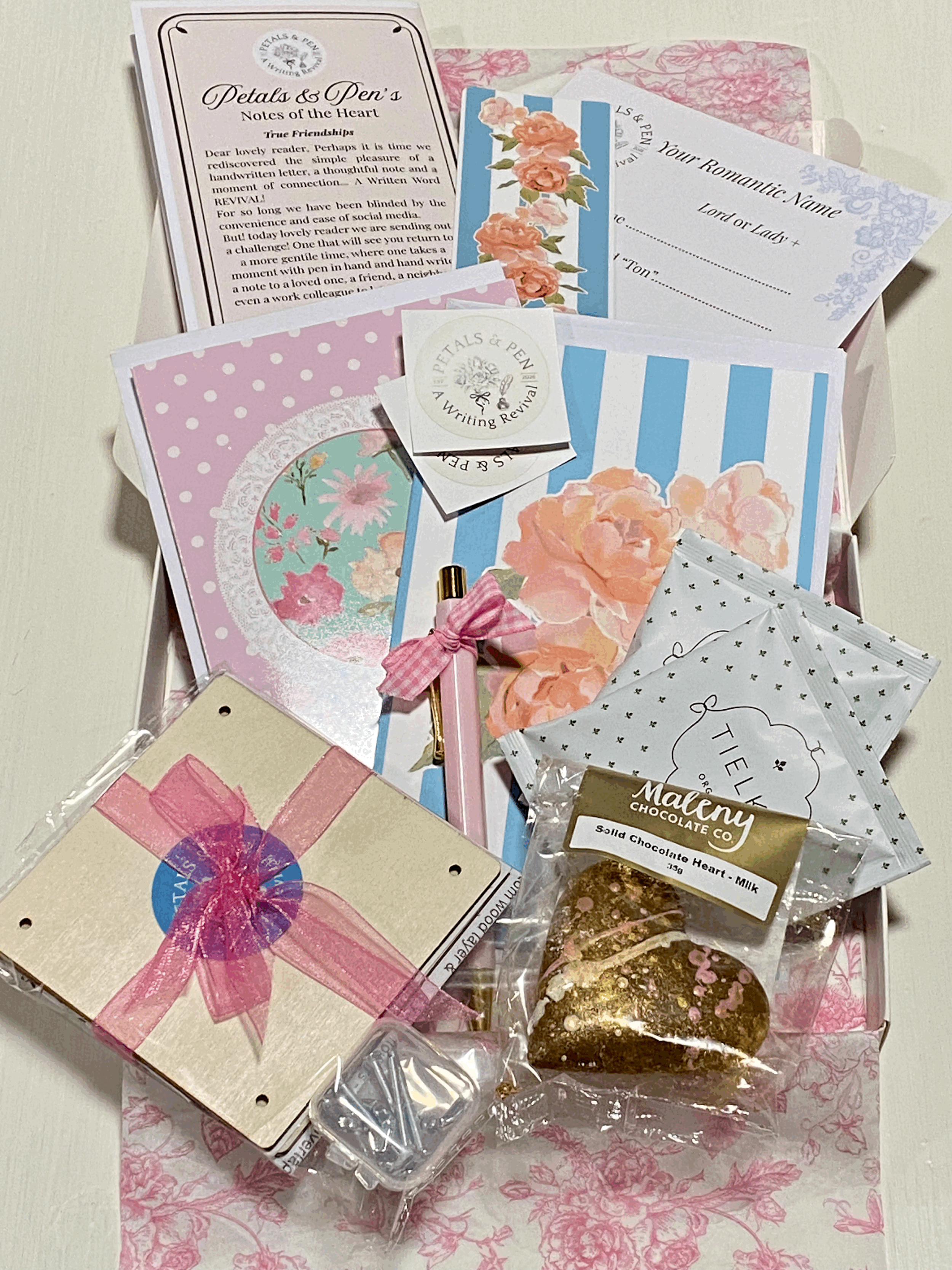 Petals & Pen romantic friendship gift box by Missy Wildflower, featuring floral stationery, handwritten letter-writing prompts, a pink pen, romantic name game, artisan tea, Maleny chocolate heart