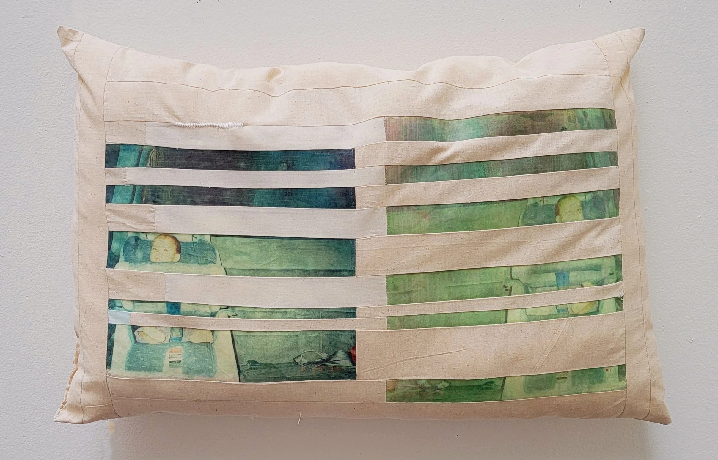 Decorative pillow with textile pieced mirrored image transfers of a child in a car seat.