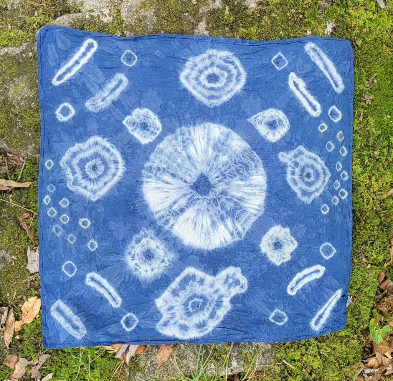 Yoruban Indigo on organic cotton bandana utilizing traditional Yoruban motifs such as the "moon" and the "stars" and "cowrie shells". 23" x 23". 2024.