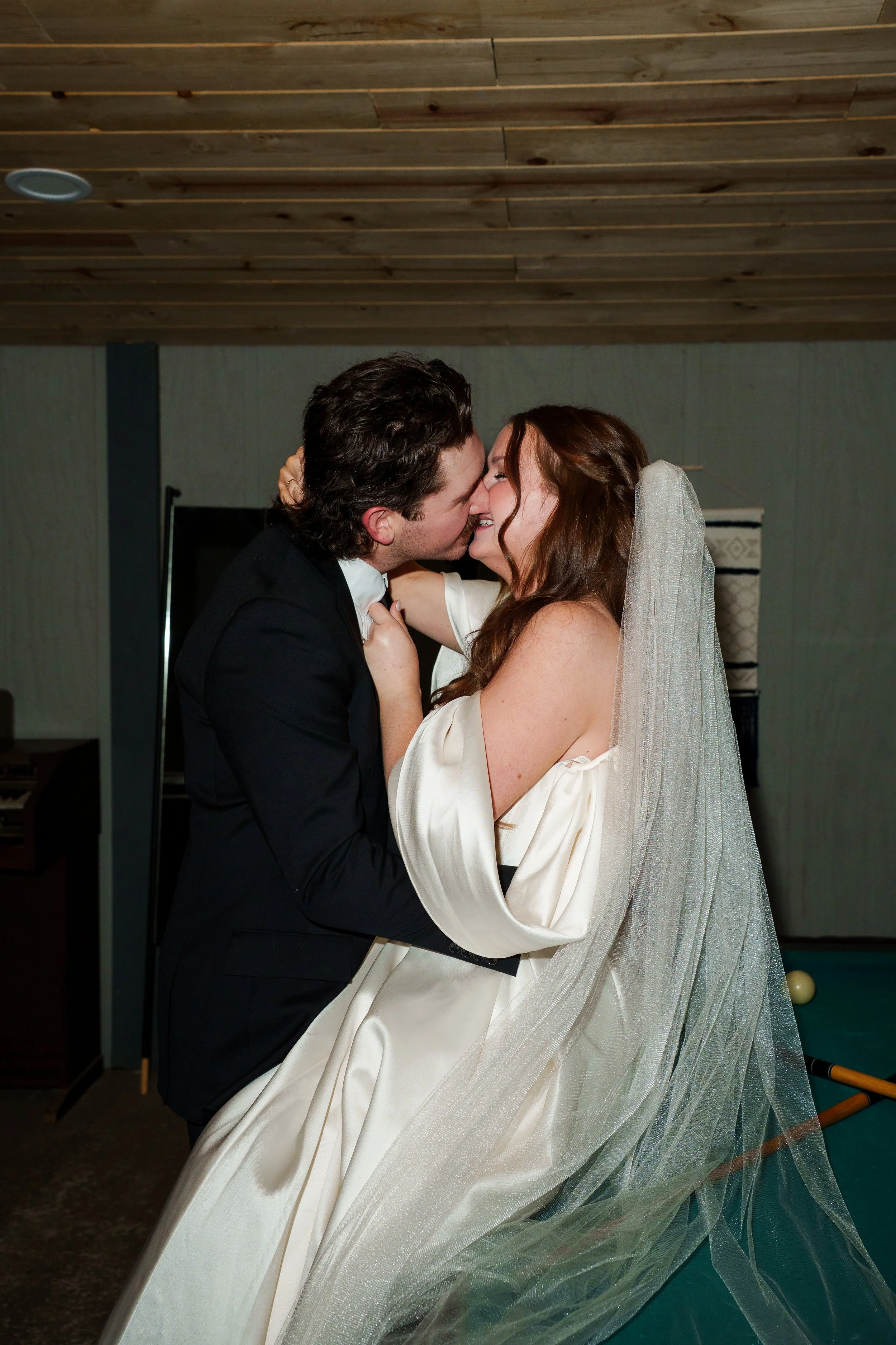Bride grabbing the Groom's tie while they kiss