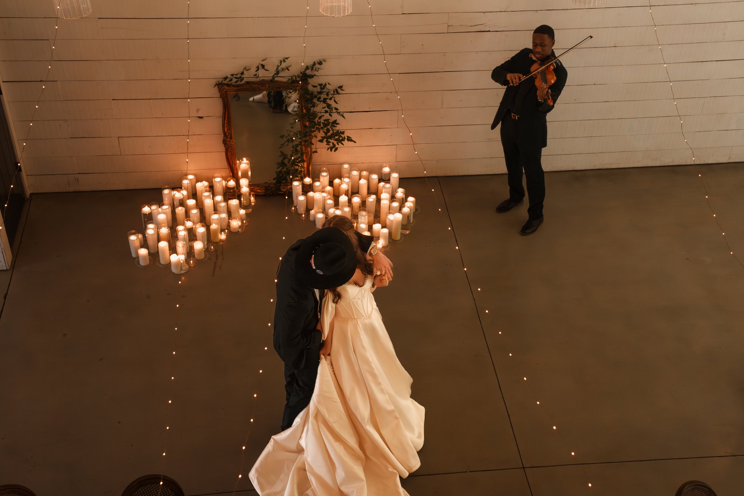 Bride and groom dancing close with a violinist playing for them
