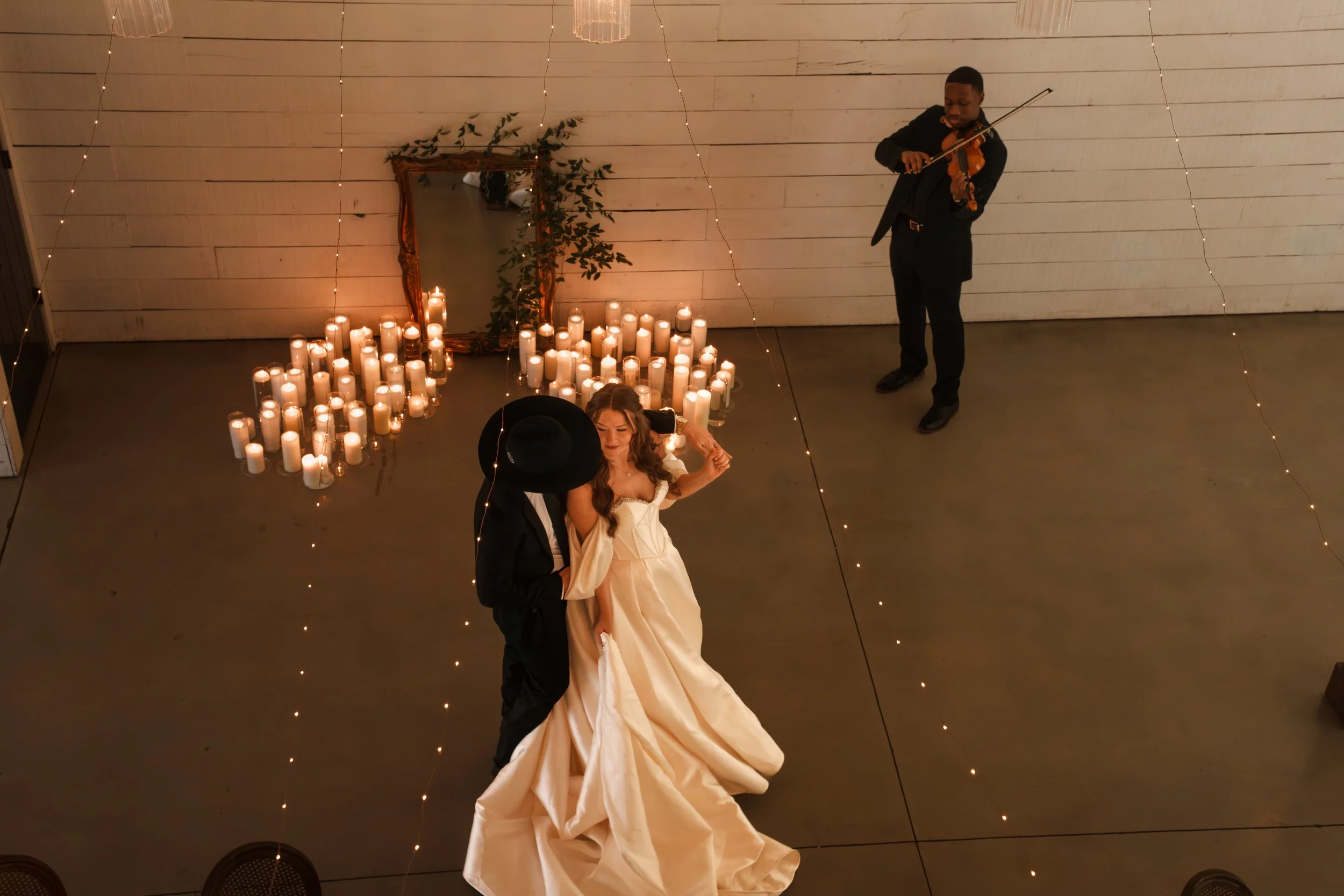 Bride and groom dancing close with a violinist playing for them