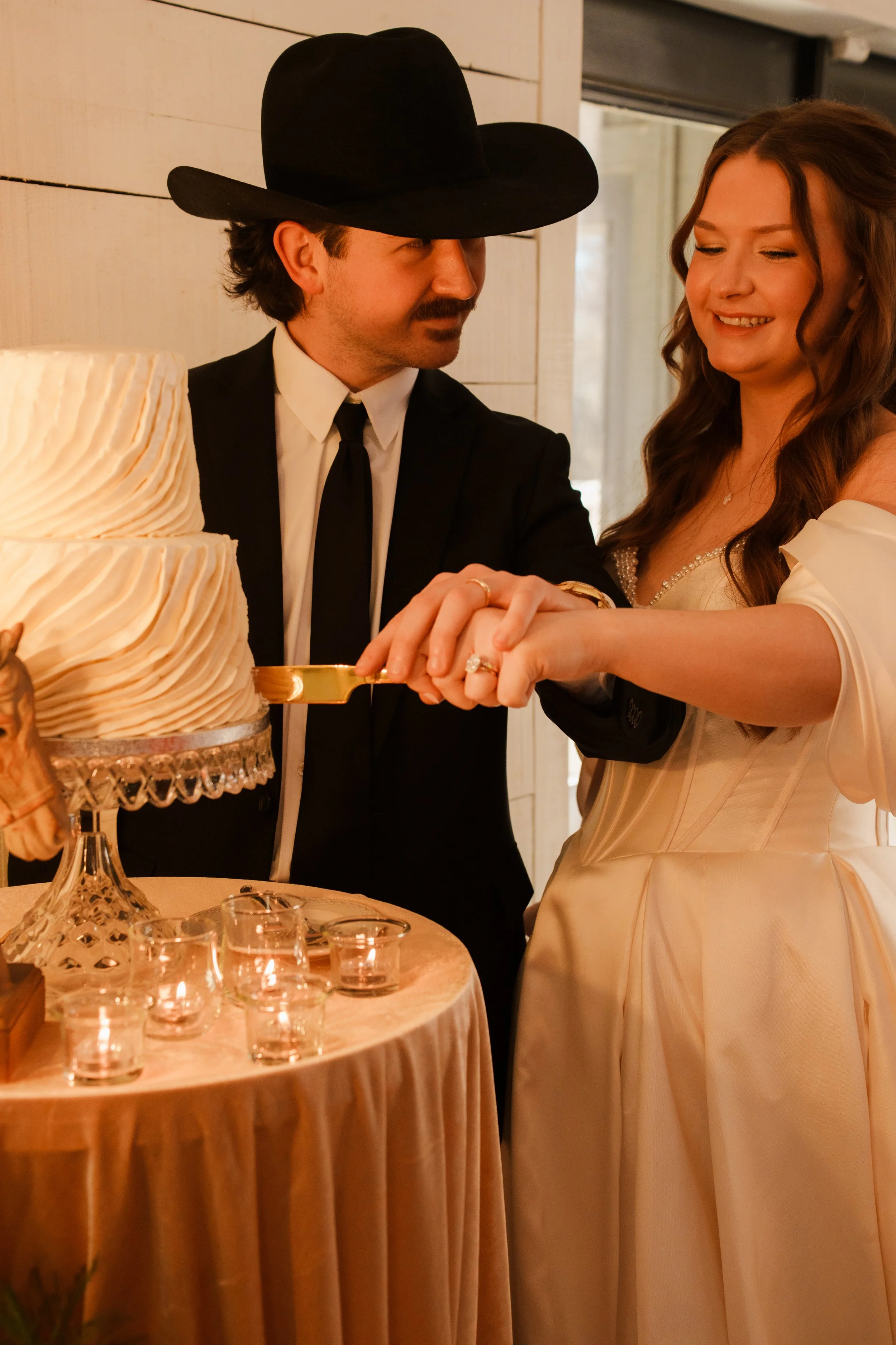 Groom admiring his bride while they cut their cake