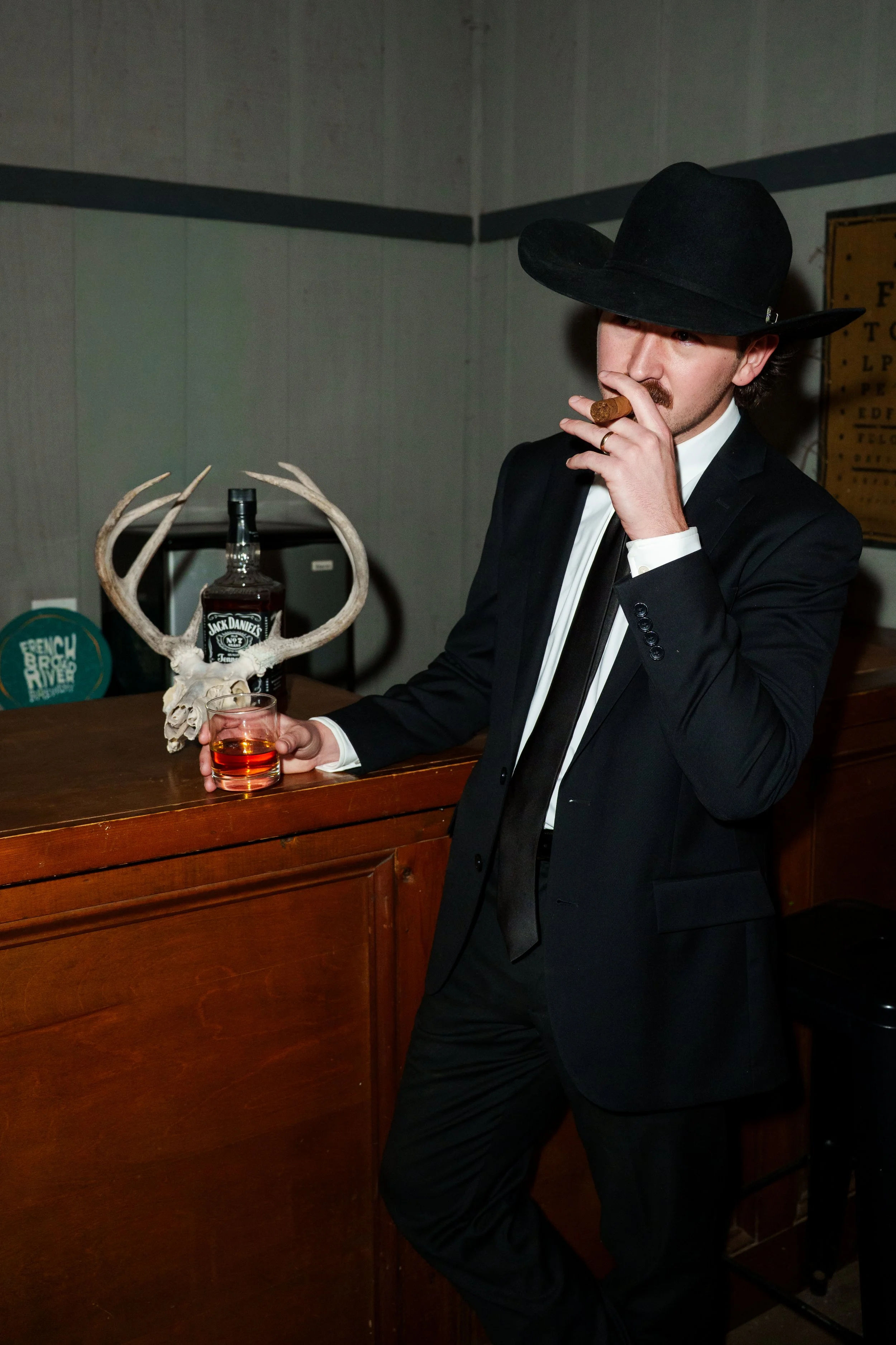 Groom smoking a cigar with a glass of whiskey in his other hand