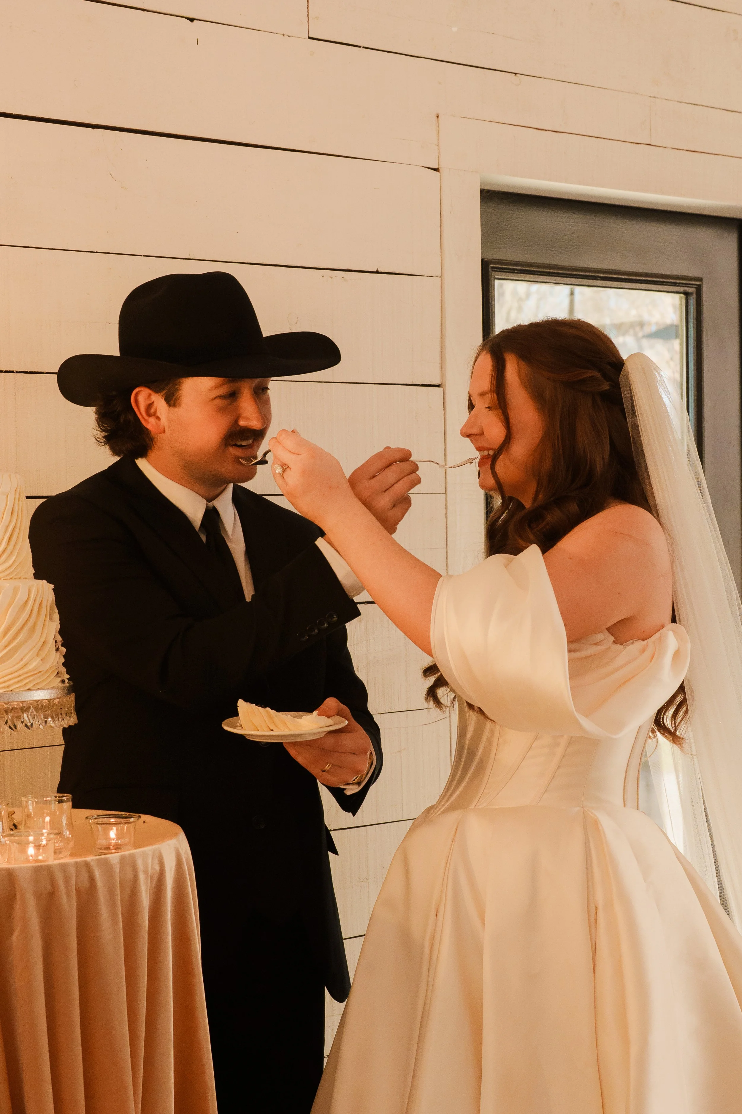 Bride and Groom feeding each other cake