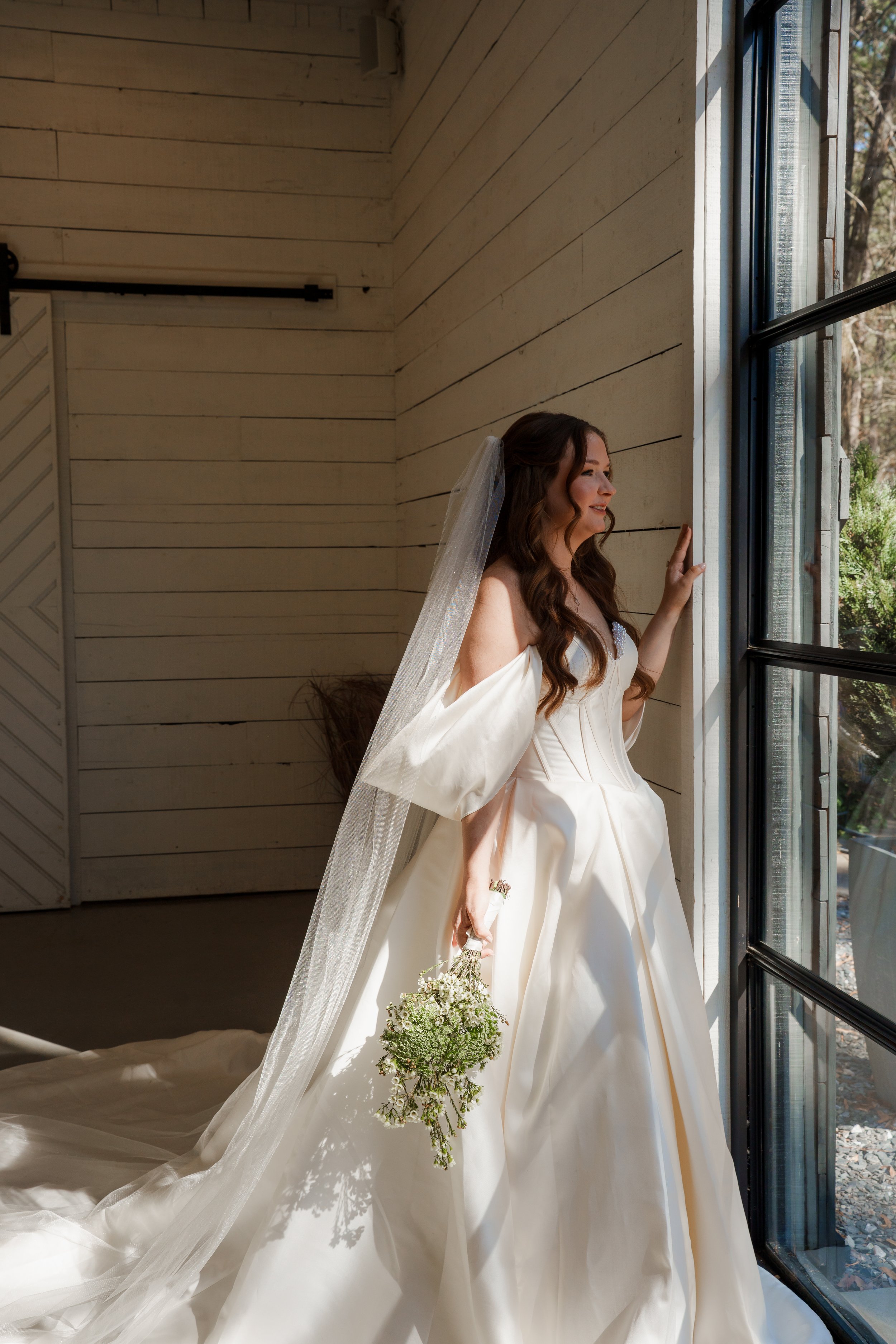 Bride staring out the window in her wedding dress