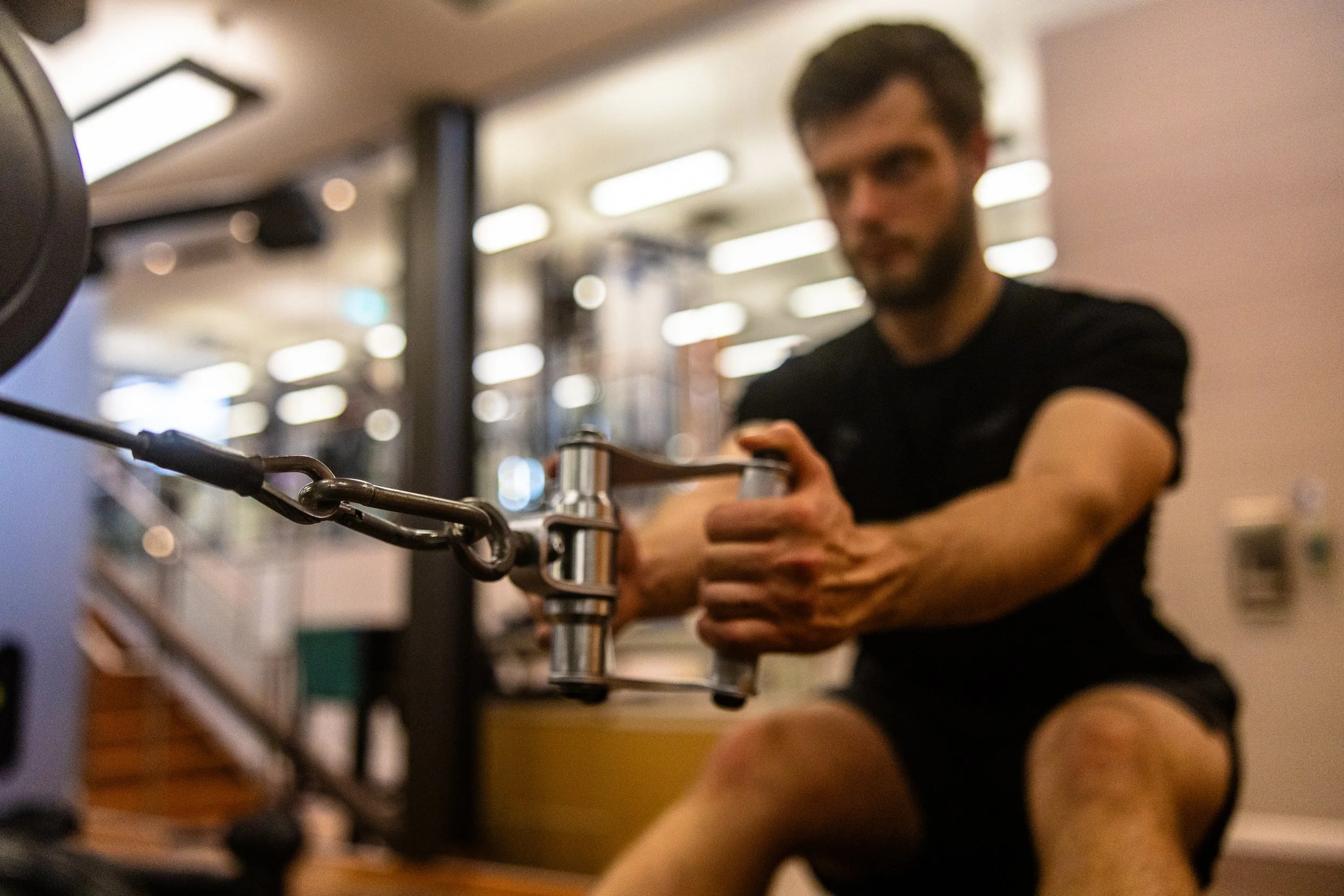 A man working out on a rowing machine in a gym.