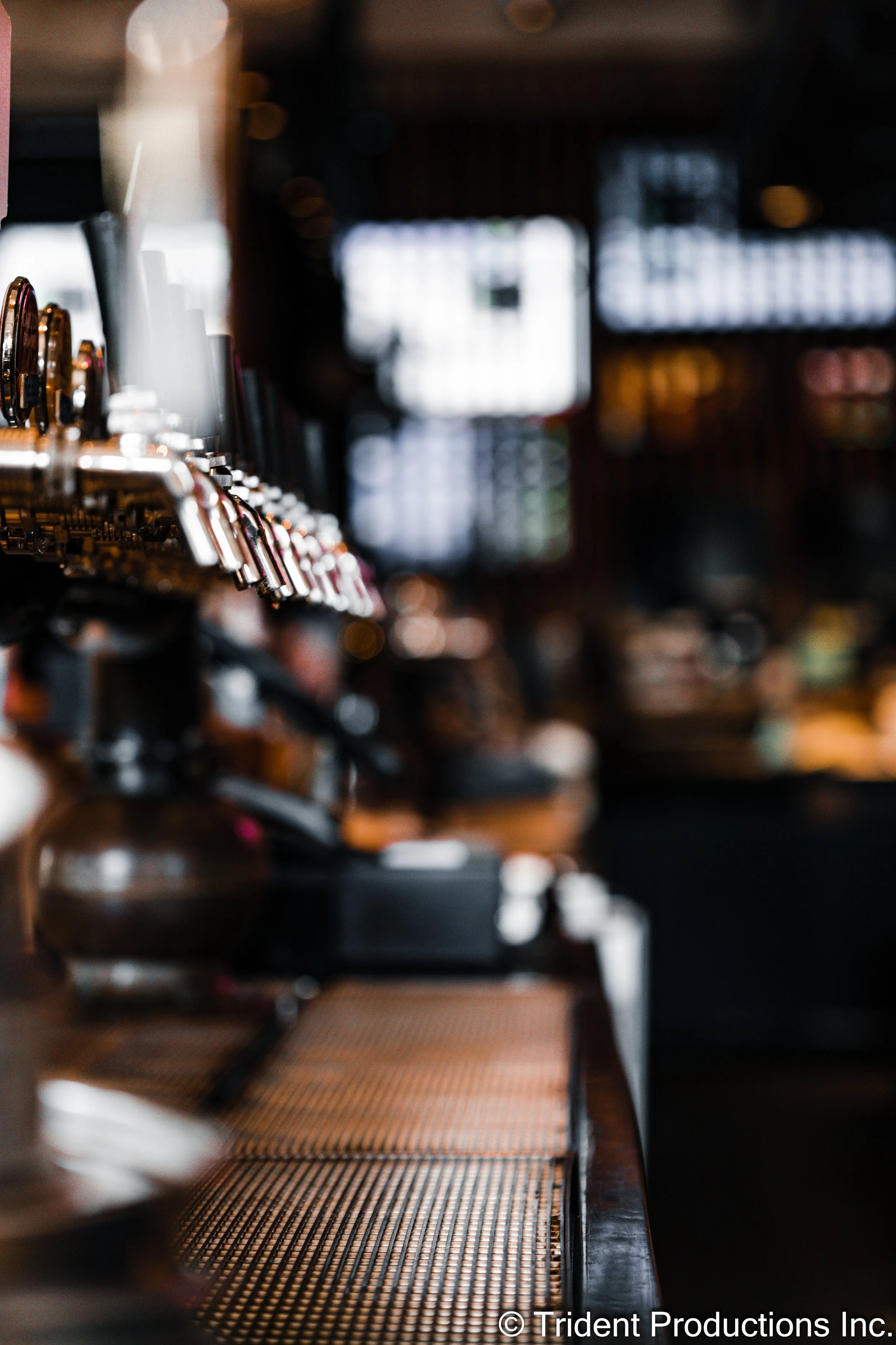 Close-up of a coffee espresso machine with the brew heads on the left, on a bar counter in a coffee shop.