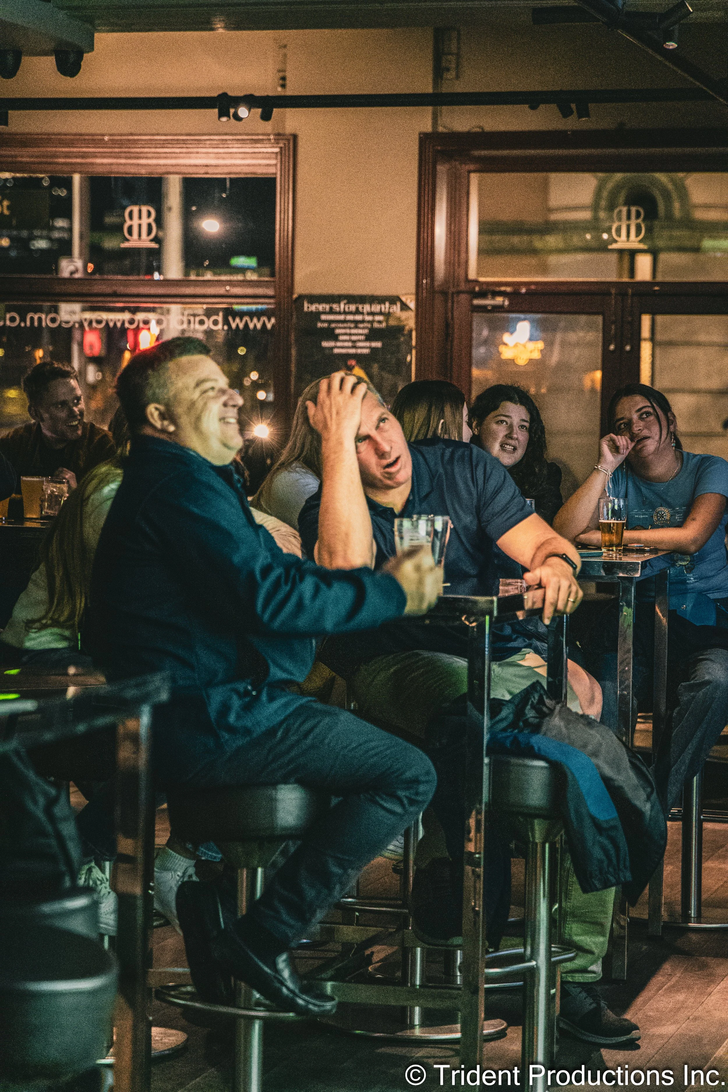 People at a bar or pub, laughing and enjoying drinks.
