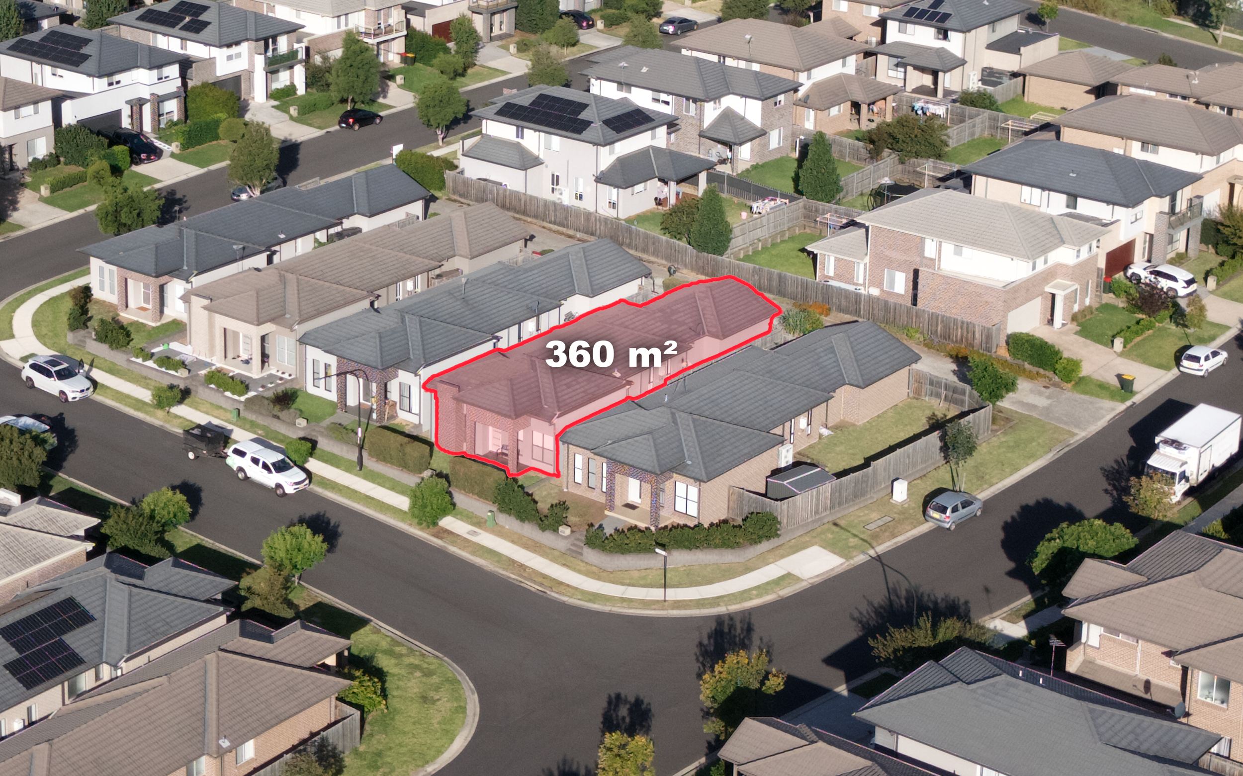 Aerial view of a neighborhood with houses, trees, and cars parked on the street. A specific property is outlined in red with a label indicating an area of 360 square meters.