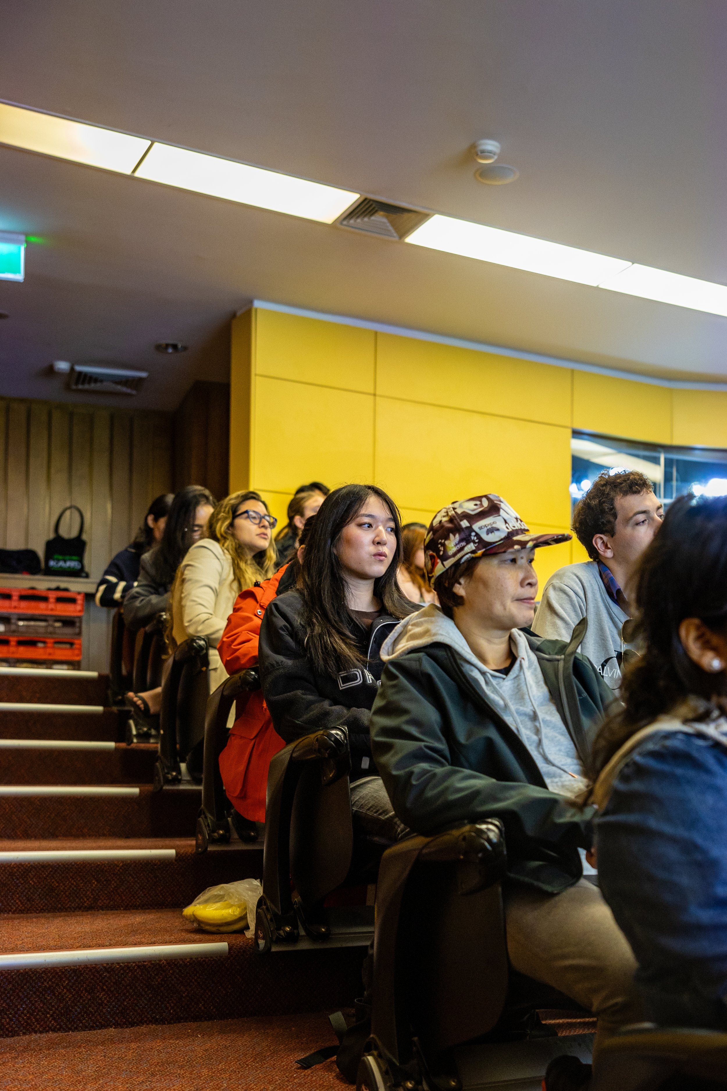 Group of people seated in an auditorium or lecture hall listening attentively.