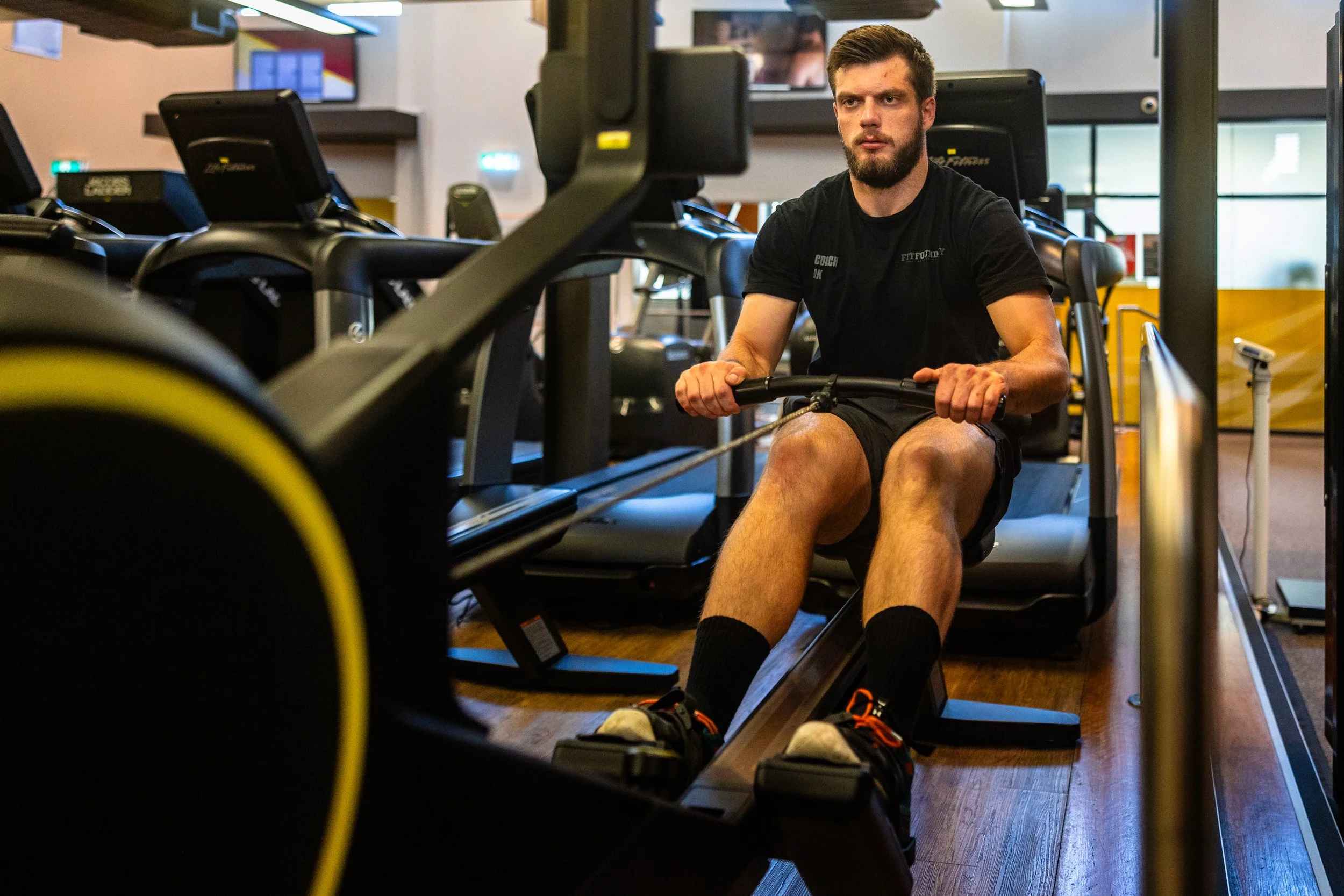 Man working out on rowing machine at gym.