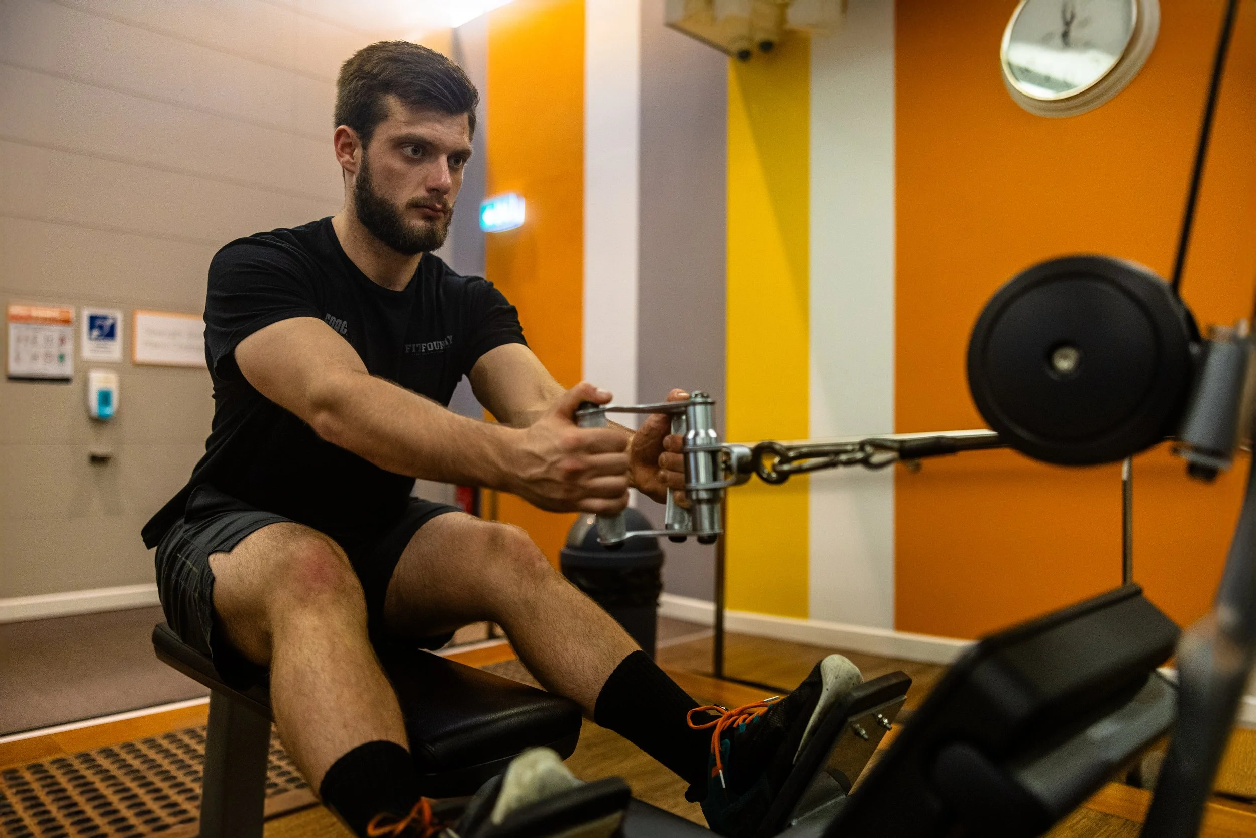 Man exercising on a rowing machine in a gym.
