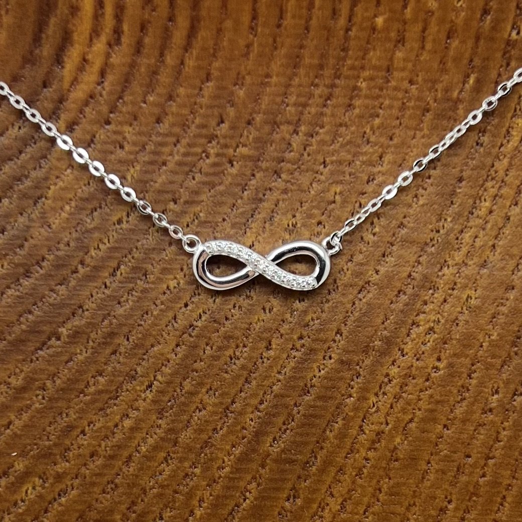 Close up of frequency infused Infinity Necklace, sterling silver with zircons.