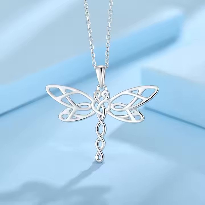 Dragonfly grounding jewelry photographed upon a black background.