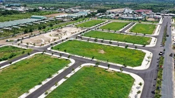 Aerial view of an empty residential development with plots, paved roads, and green landscaping.