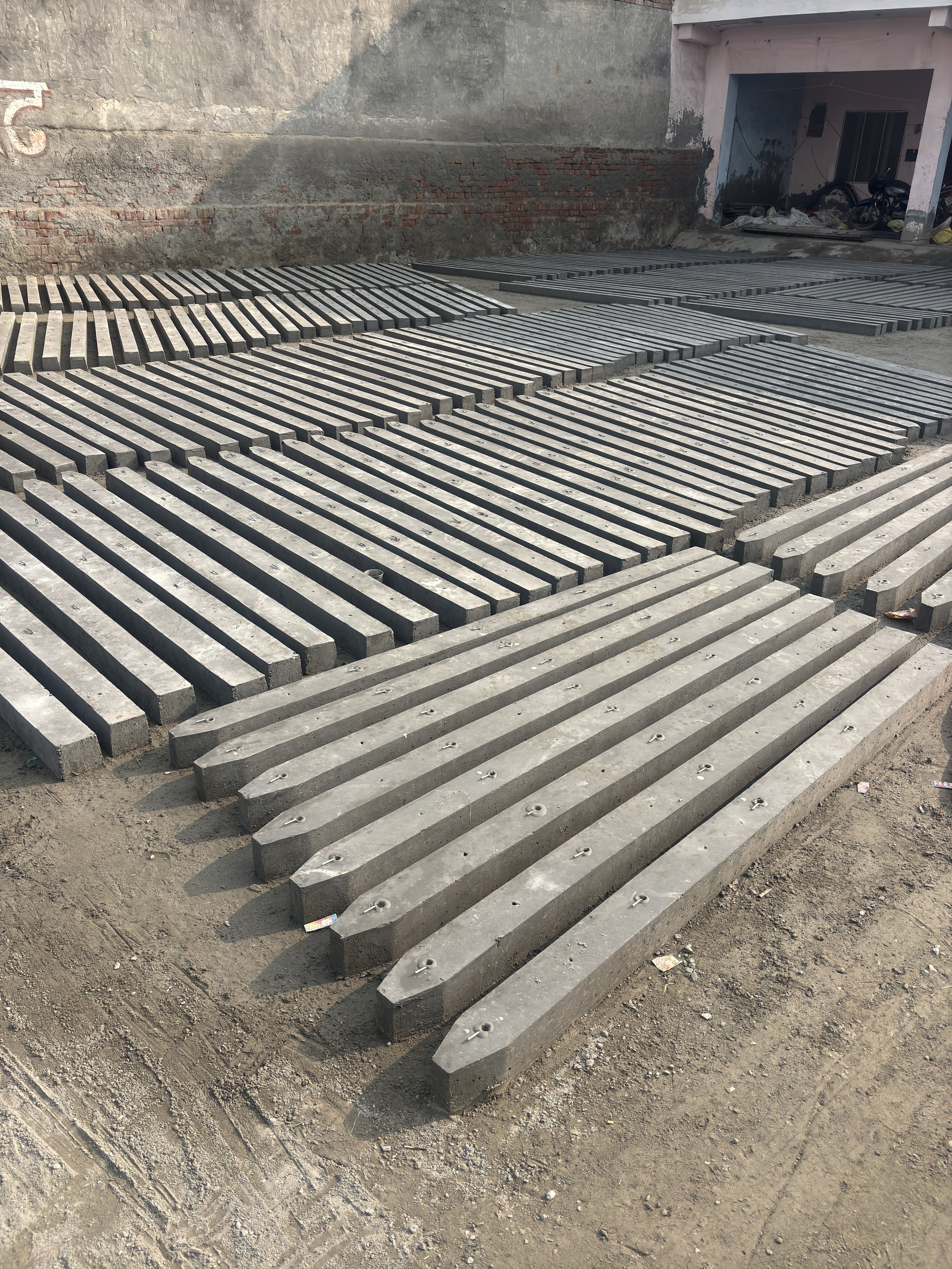 Multiple concrete road barriers arranged in rows at a construction site.