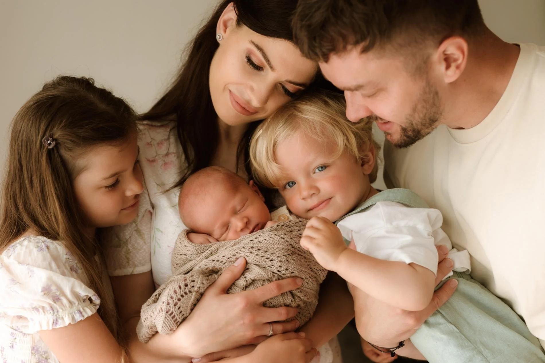 rodinná fotografie s miminkem - rodina objímá miminko při newborn focení