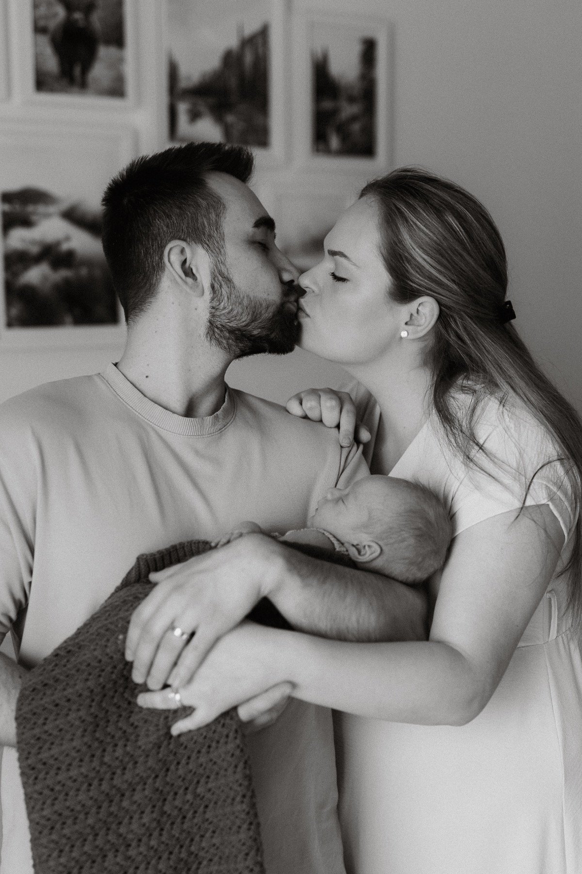  Rodiče drží své malé miminko při newborn focení. 