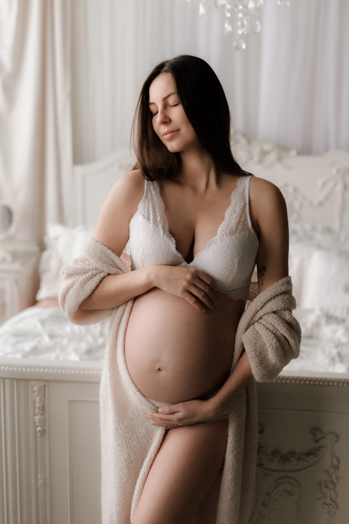 Přirozené těhotenské fotky - žena si hladí těhotenské bříško při těhotenském focení v Olomouci