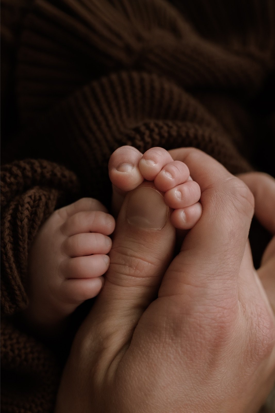 Novorozenecké focení Olomouc - detail nožiček v ruce rodiče